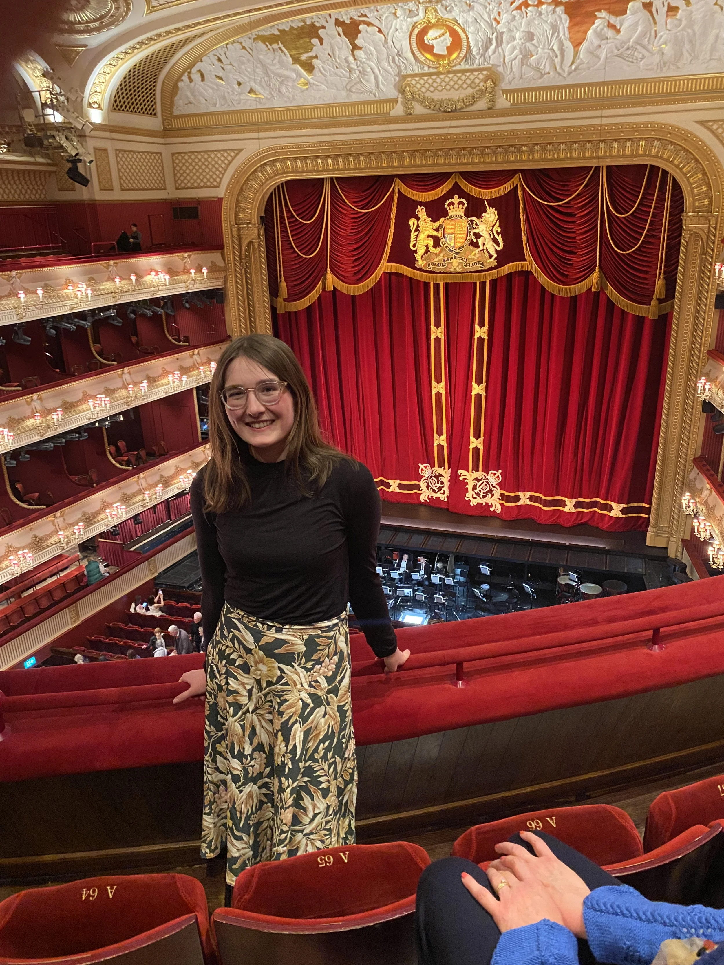 A woman standing in the amphitheatre of the Royal Opera House.