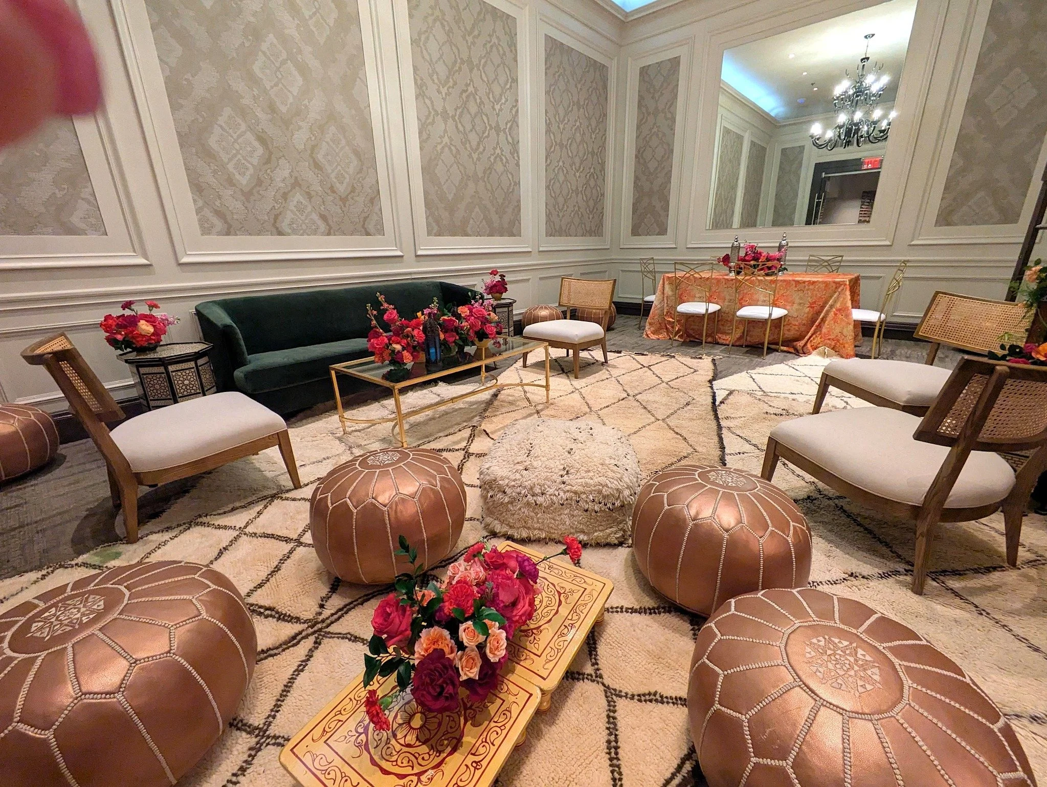 Moroccan lounge with leather poufs, carved low tables, patterned rugs and lounge seating