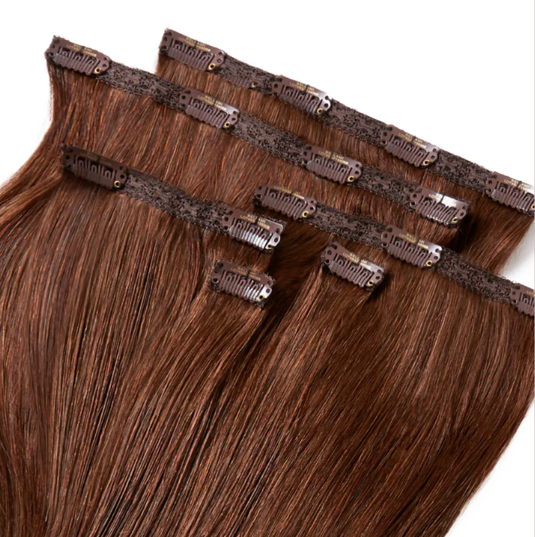 Close-up of brown hair extensions with multiple micro-link or micro-bead connectors attached to the top of the strands.