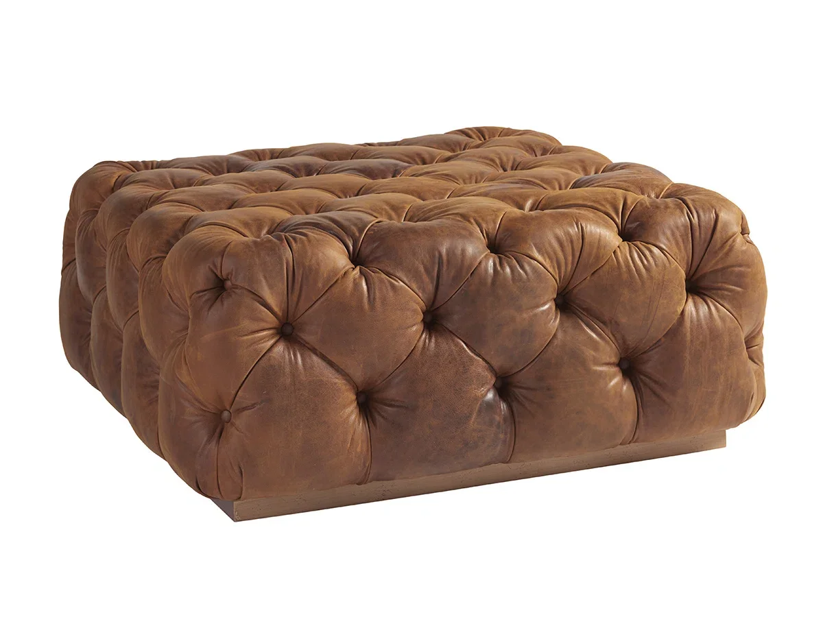 Brown tufted leather ottoman with a wooden base