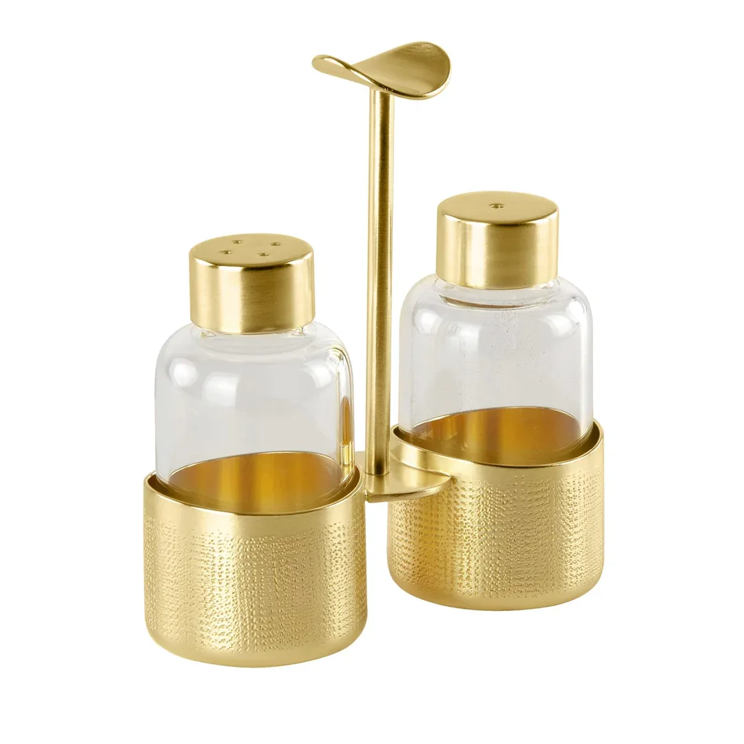 Gold-colored salt and pepper shakers with a matching condiment holder and a small spoon.
