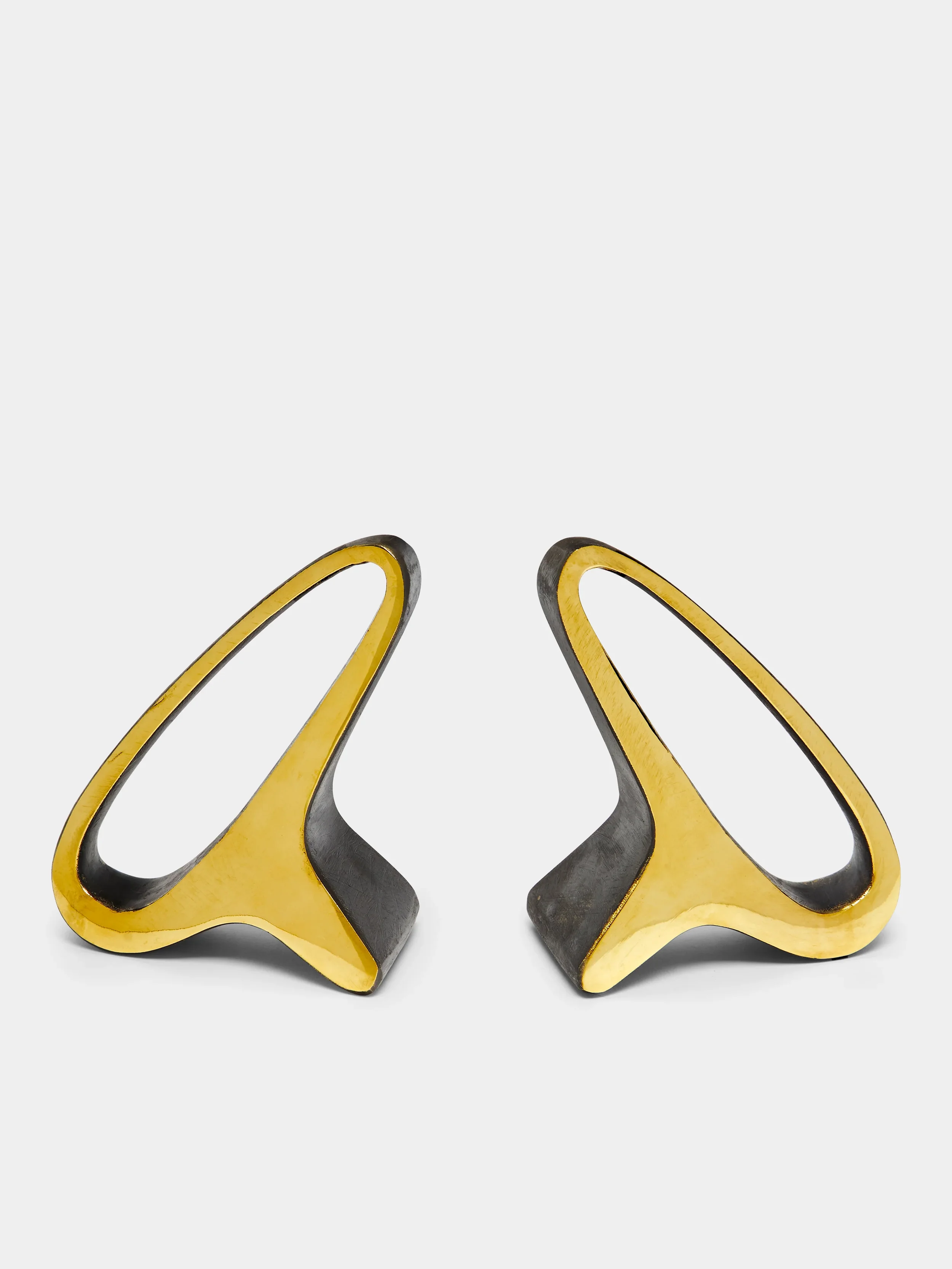 Pair of modern, abstract bookends with open, elongated oval shapes to look like ears.