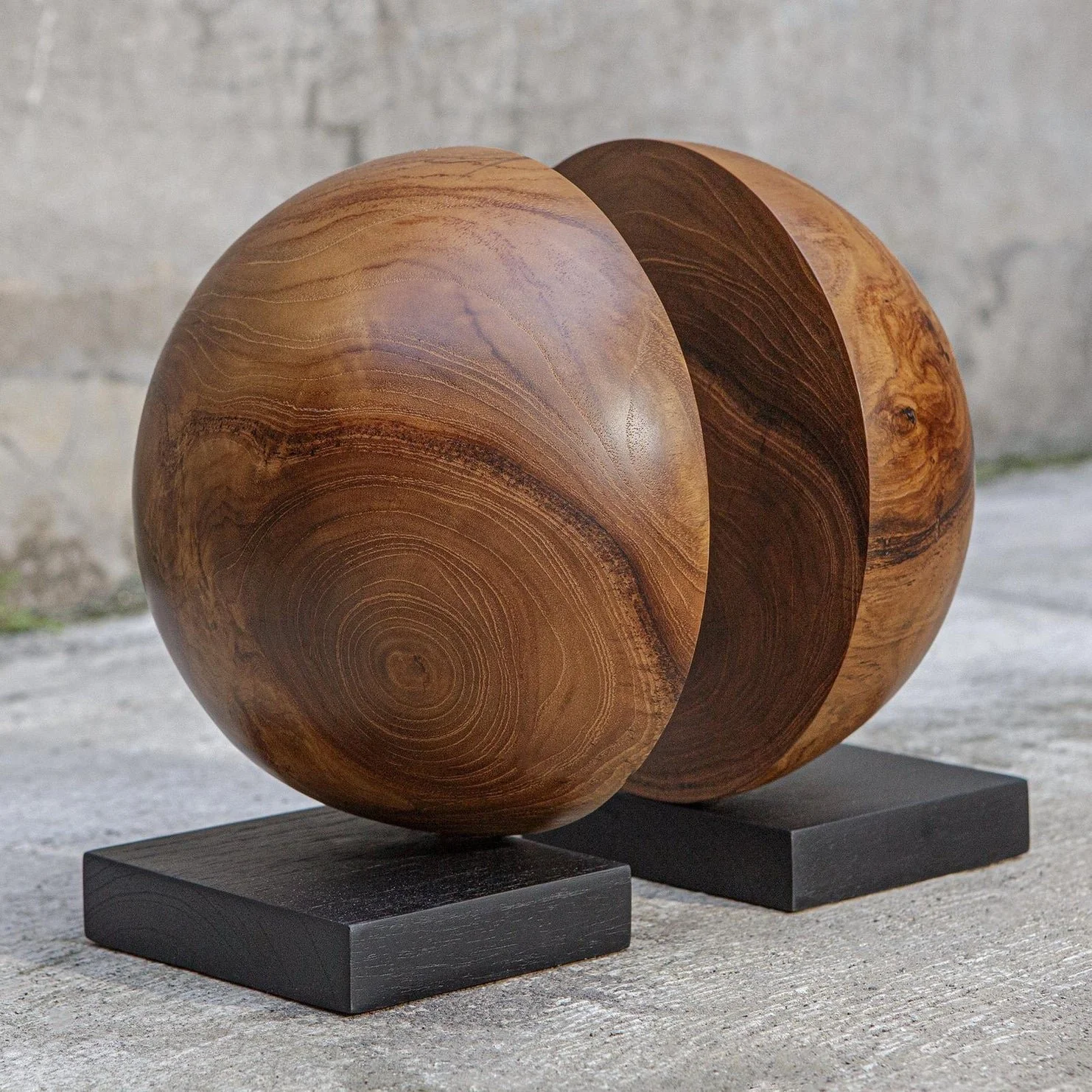half sphere book ends. natural wood grain patterns, mounted on black square bases,