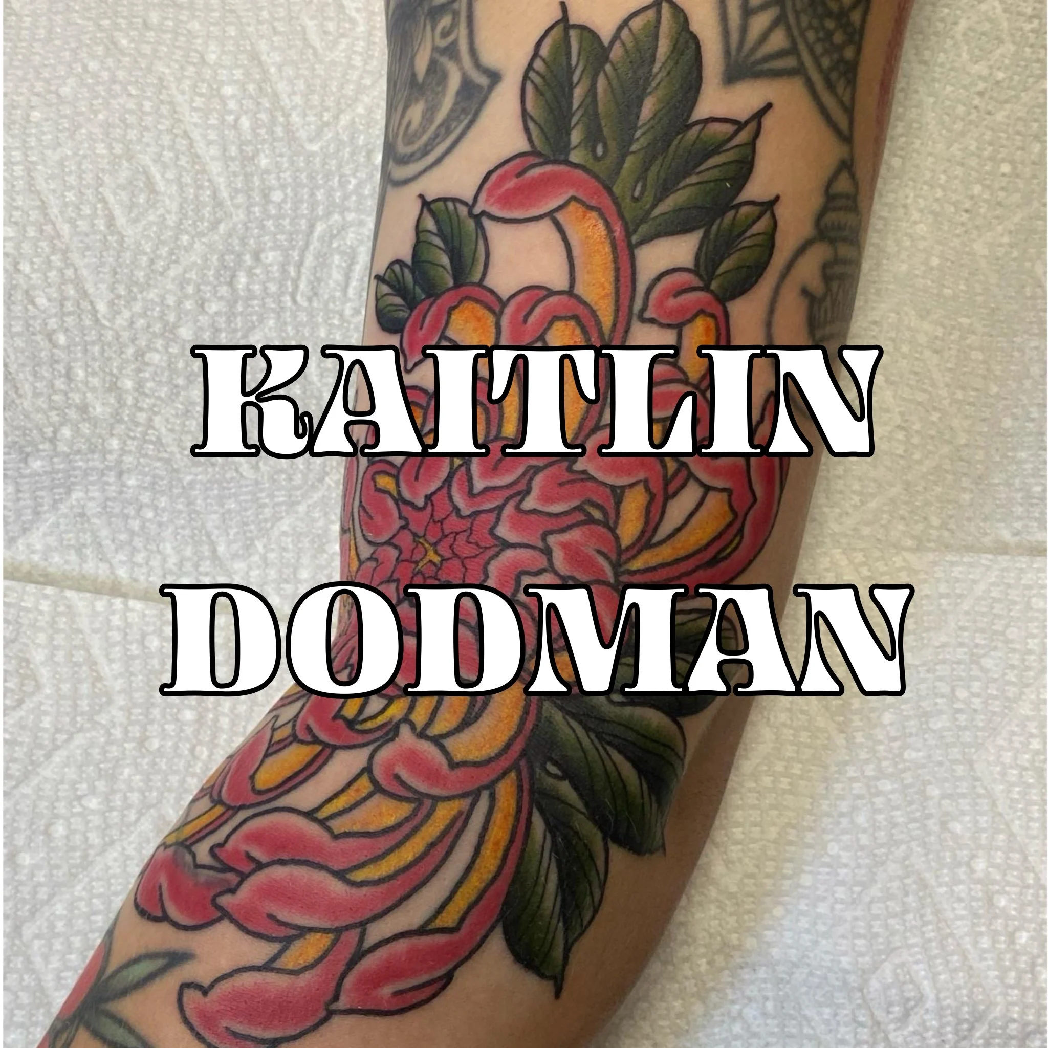 Tattoo By Kaitlin Dodman of a Pink and Yellow Chrysanthemum with green leaves on a persons arm.
