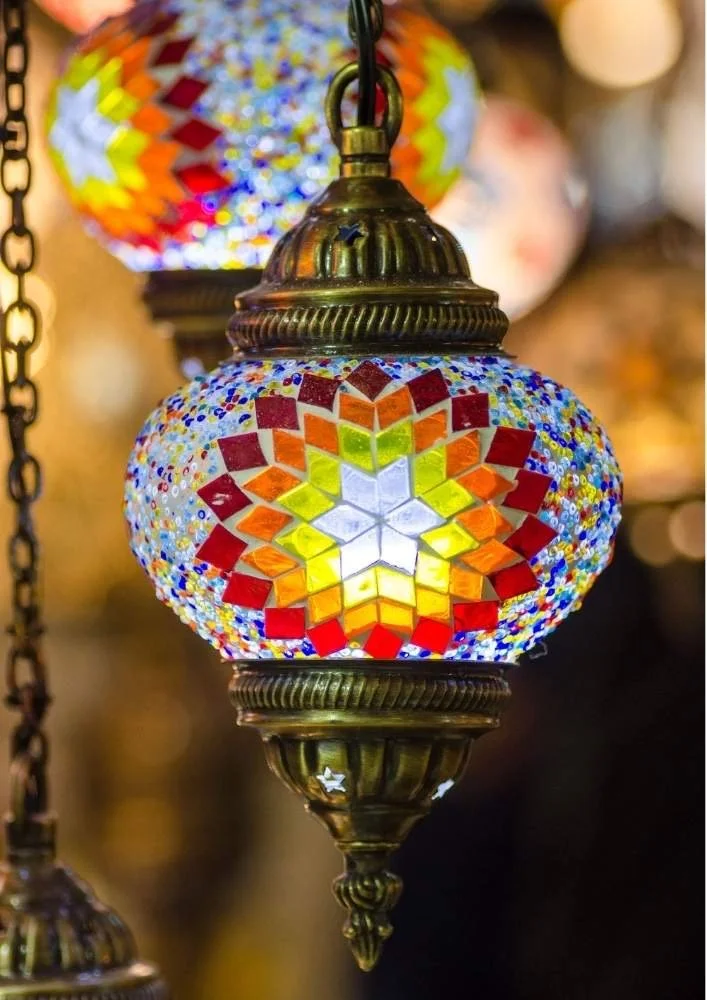 Colorful mosaic Turkish lamp with intricate geometric patterns and stained glass, hanging from a chain.