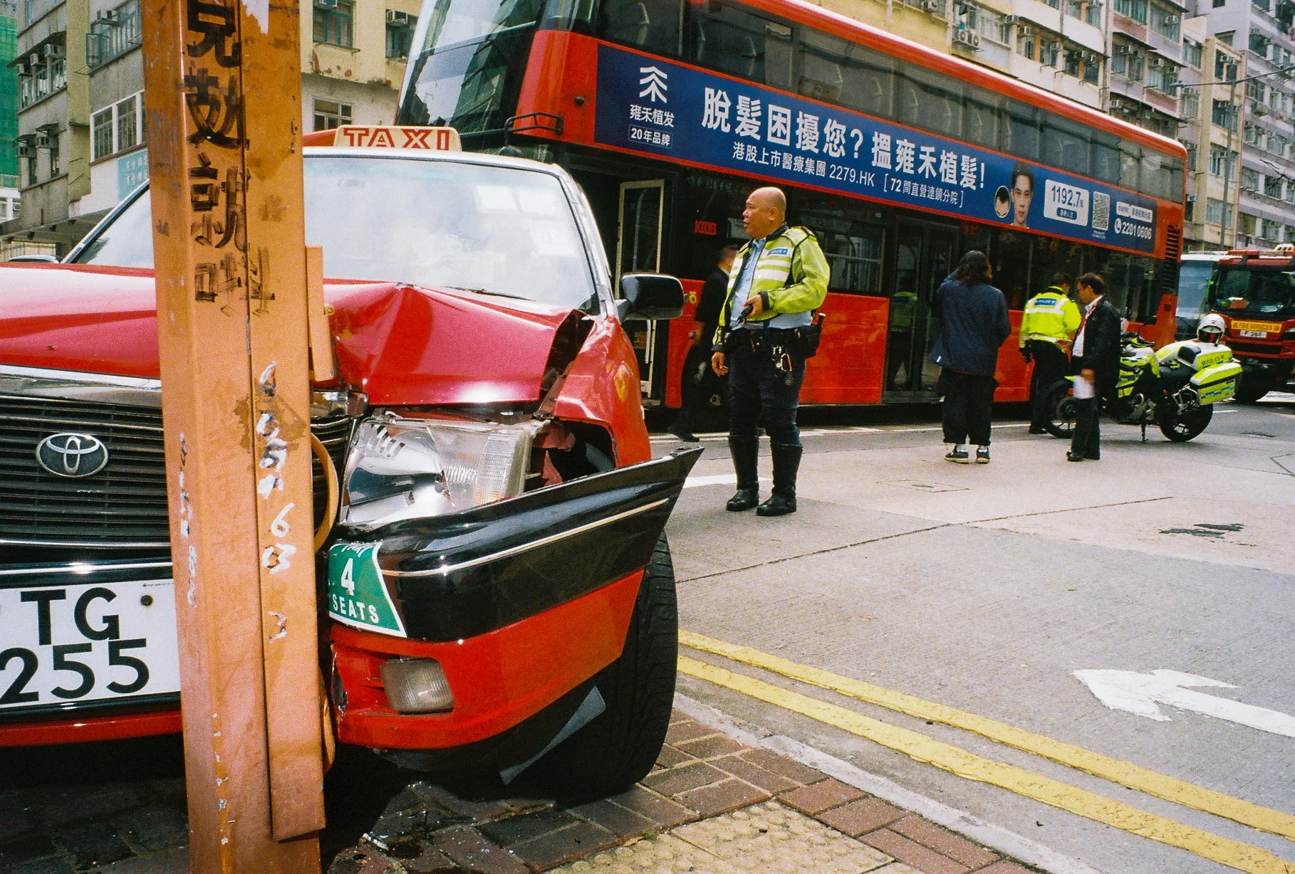 Damaged red taxi and traffic police at a street accident scene in Hong Kong