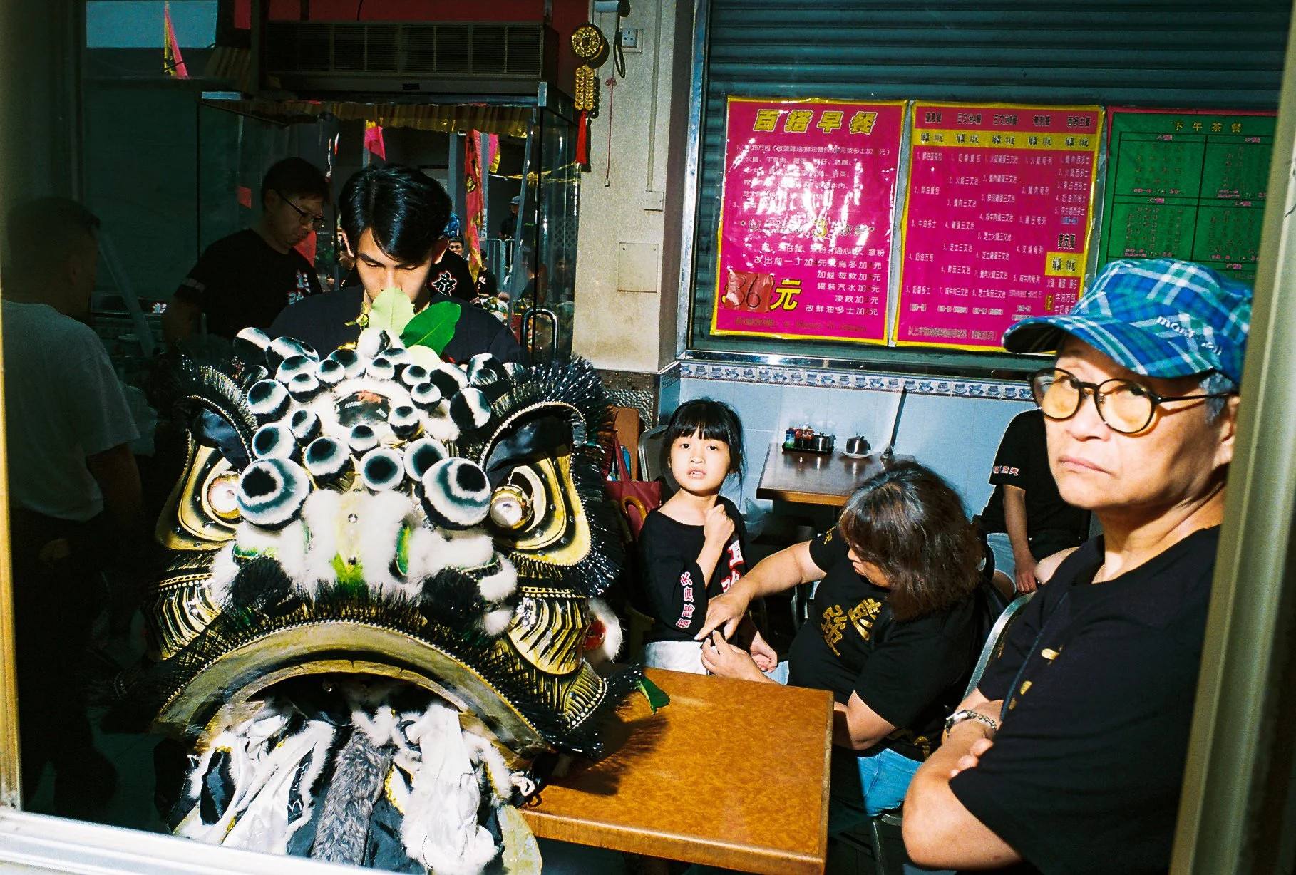 Chinese lion dance head resting on a table in a traditional Hong Kong café