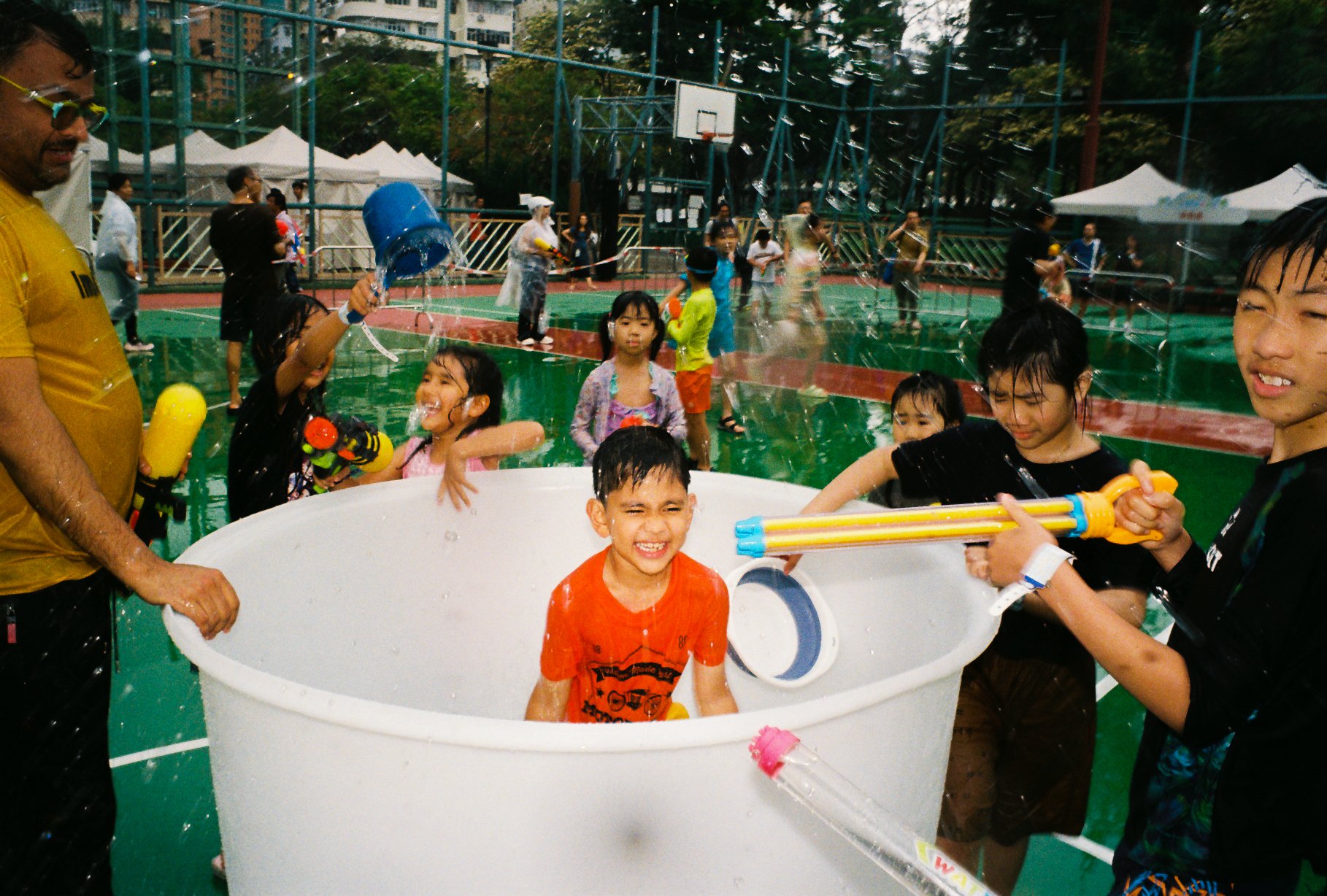Children playing with water guns at an outdoor summer event in Hong Kong