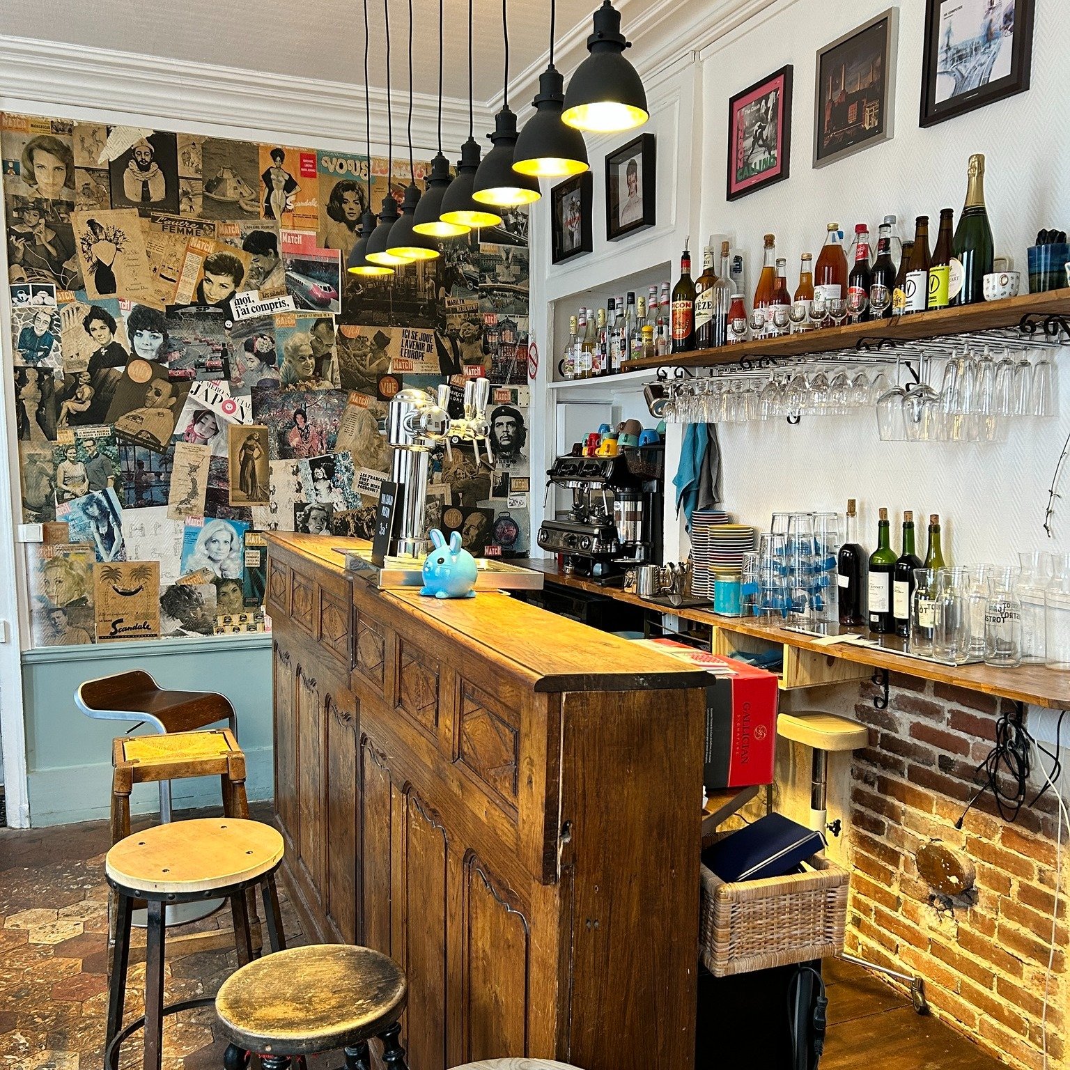 Aux Lapins Bleus, on a tout refait. Les murs, le sol, la d&eacute;co, les chambres, l'esprit du lieu.

Tout &mdash; sauf ce mur.

Ce mur, c'est l'ancien propri&eacute;taire. Des ann&eacute;es de collages, de Paris Match, de visages et de titres d&eac