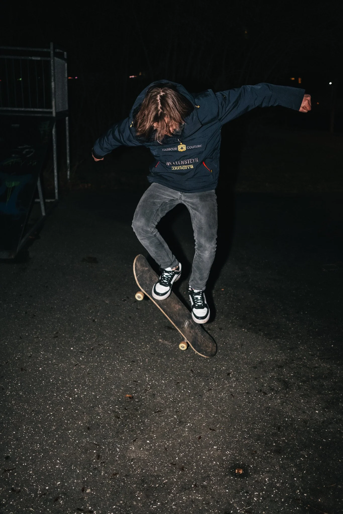Junge person beim Skateboardfahren in der Nacht.