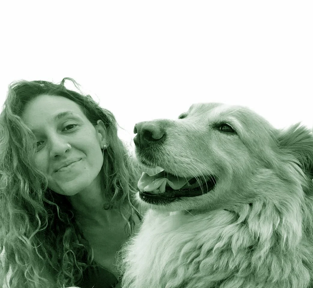 Donna con capelli riccioli e cane di razza Golden Retriever, entrambi con espressione felice, foto scattata in primo piano.