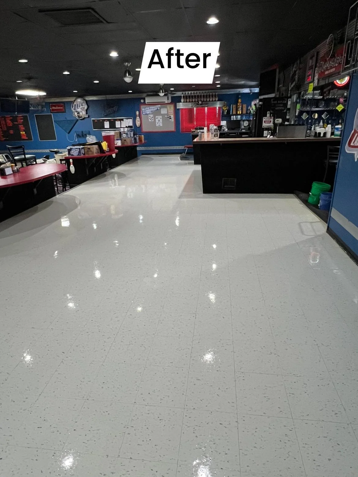 Empty indoor entertainment or recreational area with shiny white tiled floor, blue walls, red curtains, and a black counter with various equipment. The word 'After' is overlaid on the image.