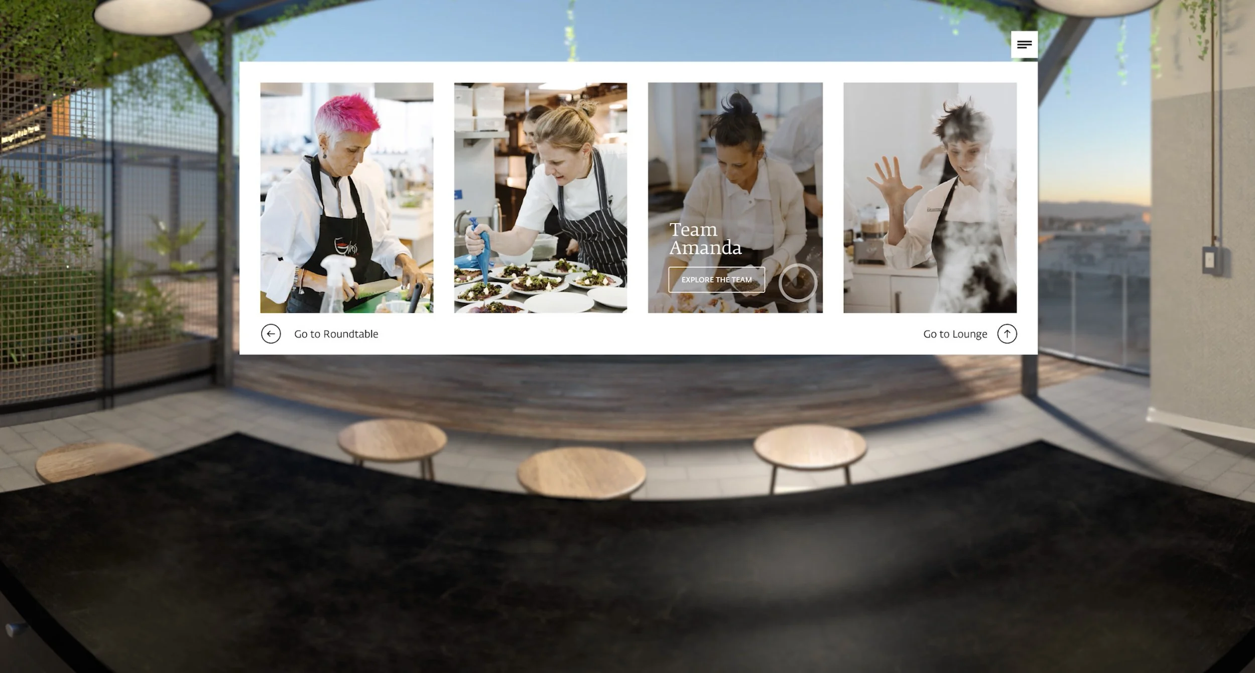 A digital display featuring four women chefs in a kitchen, preparing food. The display has options to explore the team and navigate to different sections like roundtable and lounge.