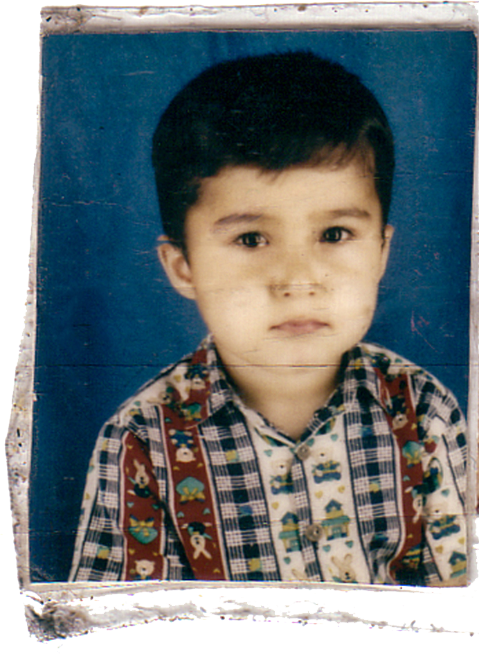 A young boy with dark hair and light skin, wearing a colorful, patterned button-up shirt, posed against a blue background.