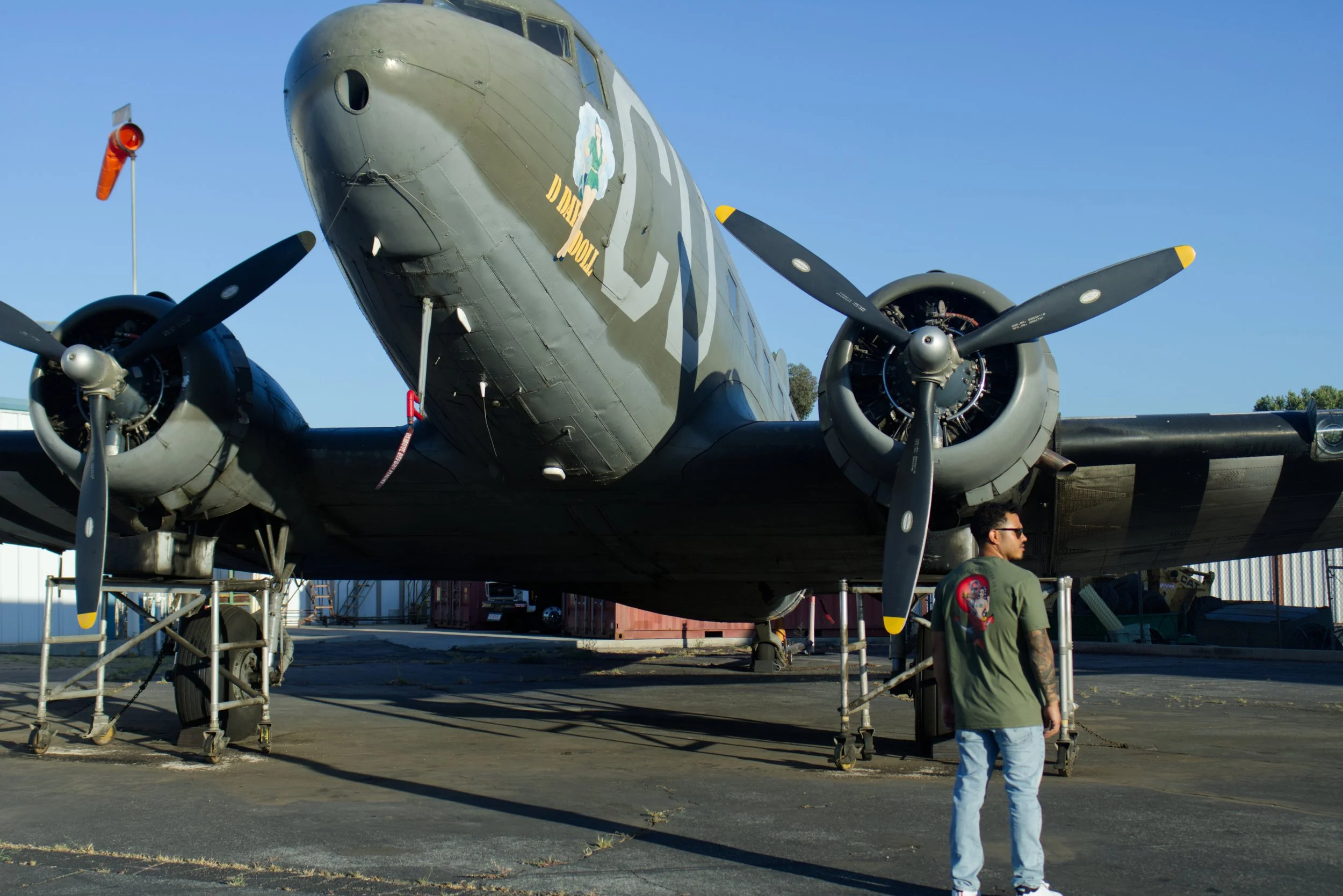 Vintage military aircraft on display outdoors with a person walking nearby