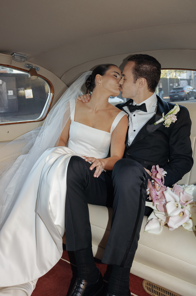 Couple in wedding car.png