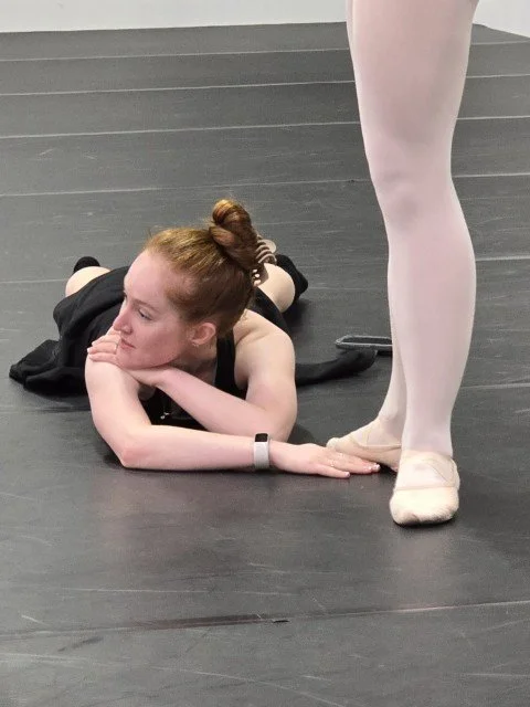 Megan Lynch giving detailed floor-level coaching to a BalletCorps student