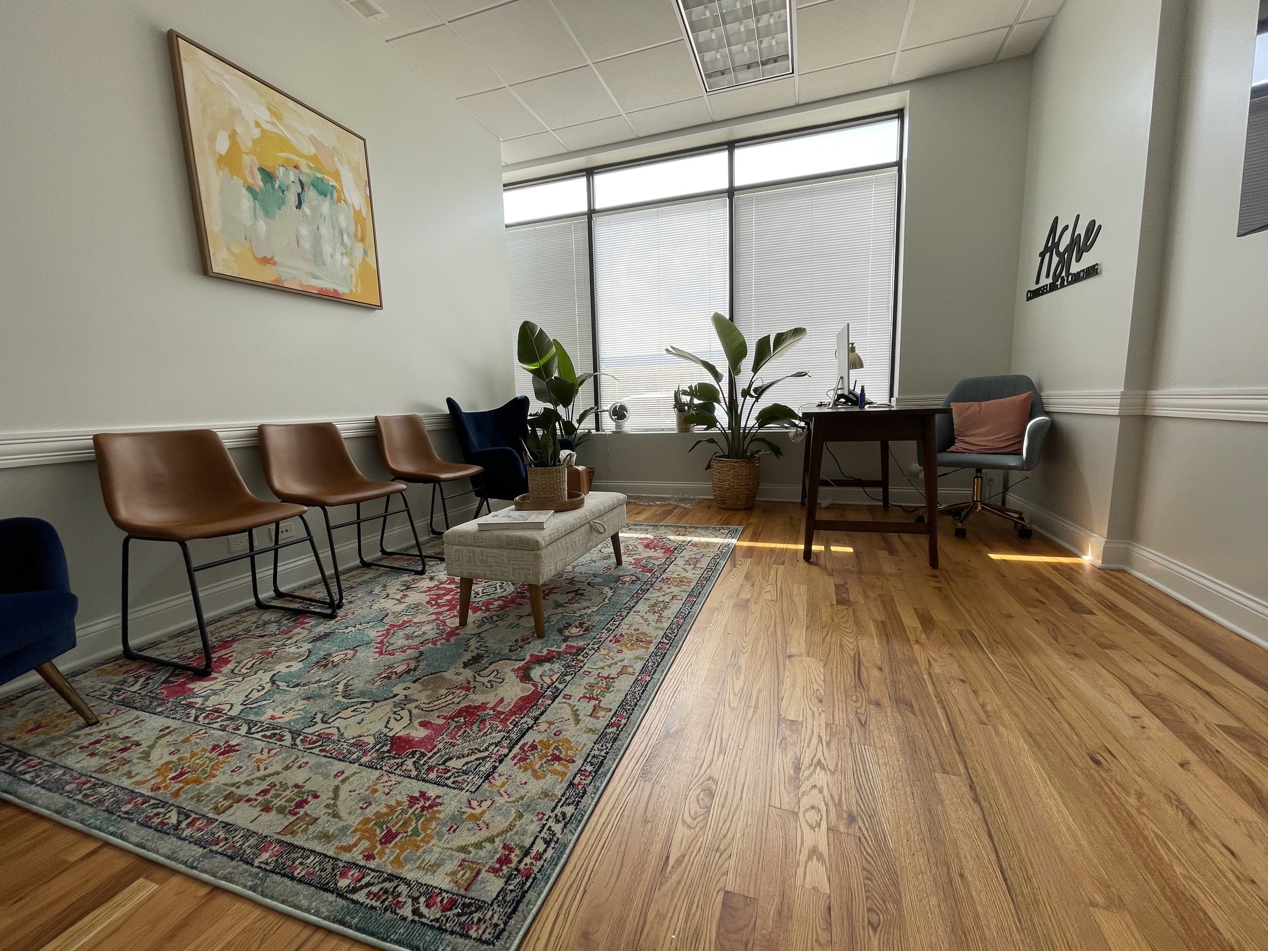ogan Square therapy office waiting room at Ashe Counseling with cozy chairs, warm lighting and inviting decor