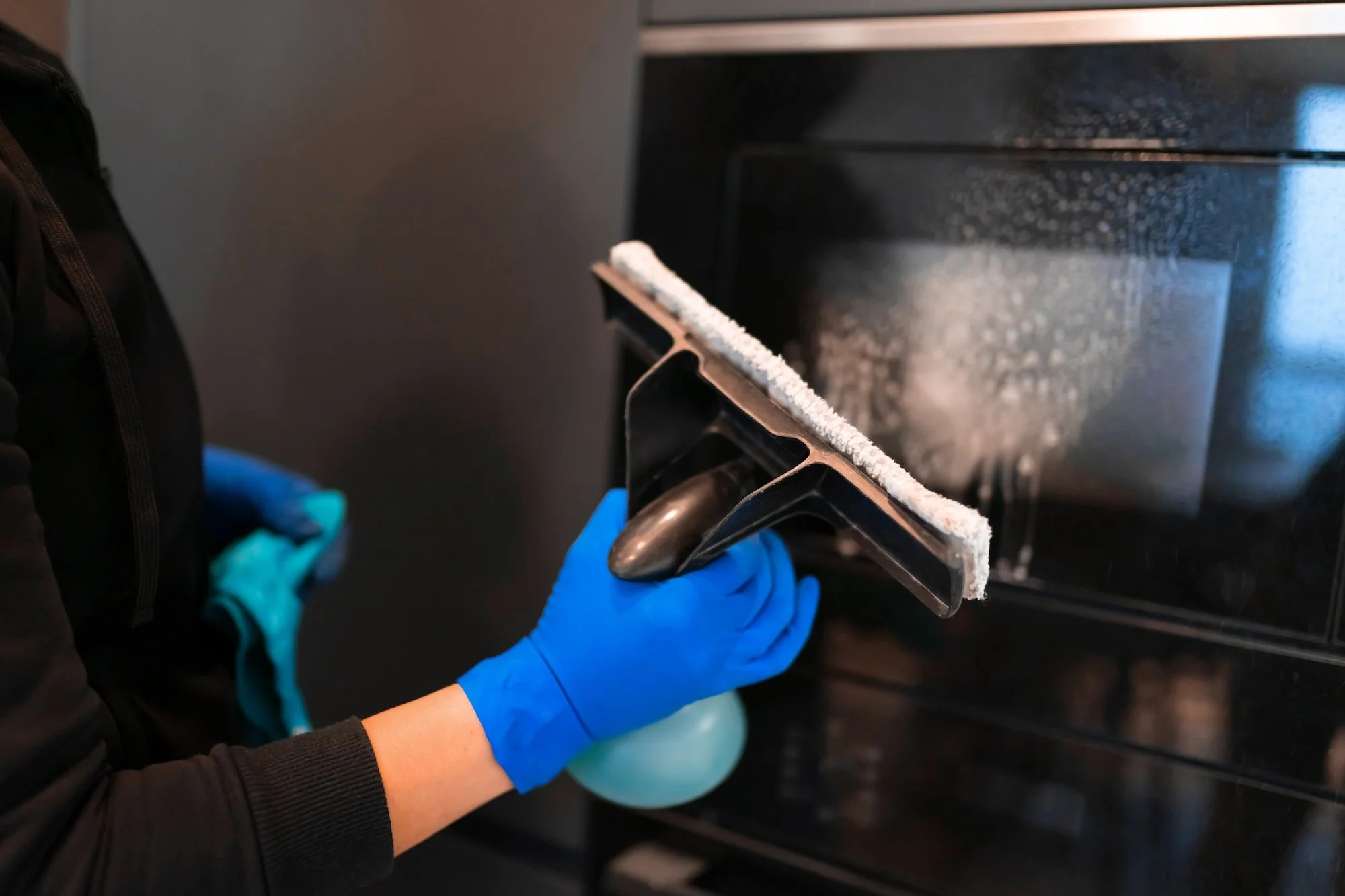woman-washing-the-glass-of-the-oven-with-a-glass-c-2024-10-18-08-22-13-utc.jpg