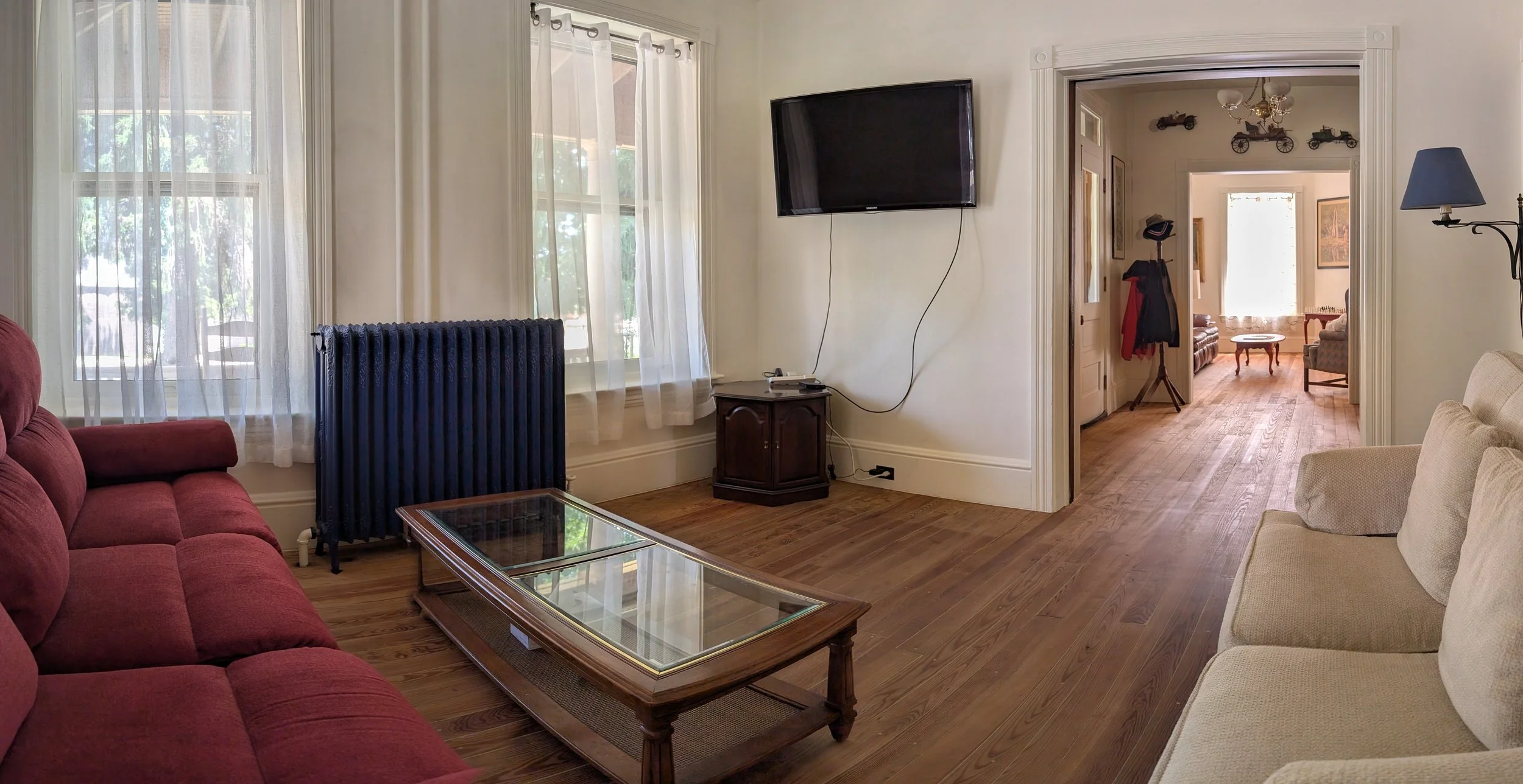 Main guest living room at Bella Vista Bed and Breakfast with comfortable seating, original hardwood floors, HDTV, and an open layout connecting the historic common areas in Akron, Pennsylvania.