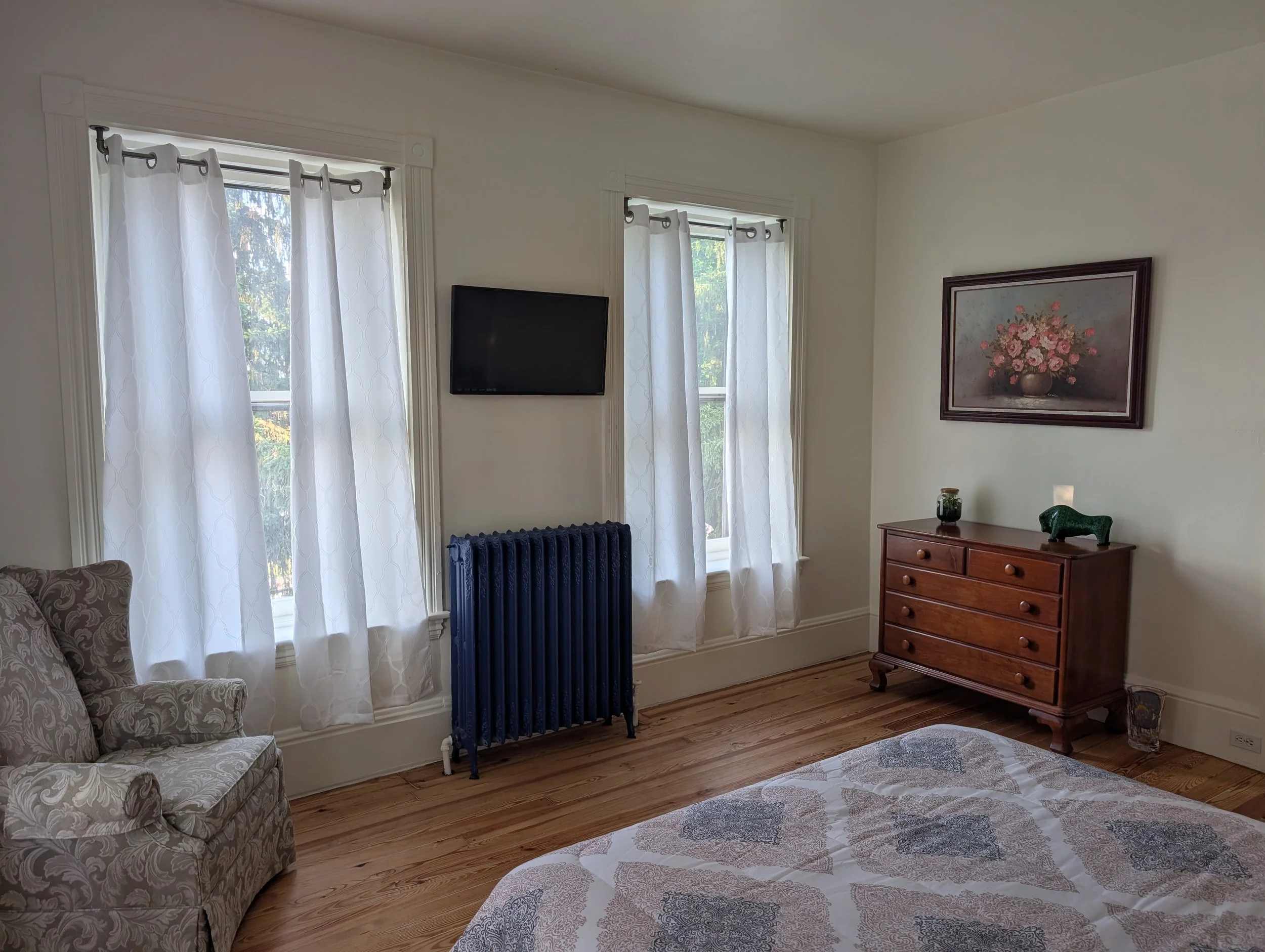 Northwest Room at Bella Vista Bed and Breakfast featuring large windows, abundant natural light, restored hardwood floors, HDTV, and antique furnishings in Akron, Pennsylvania.