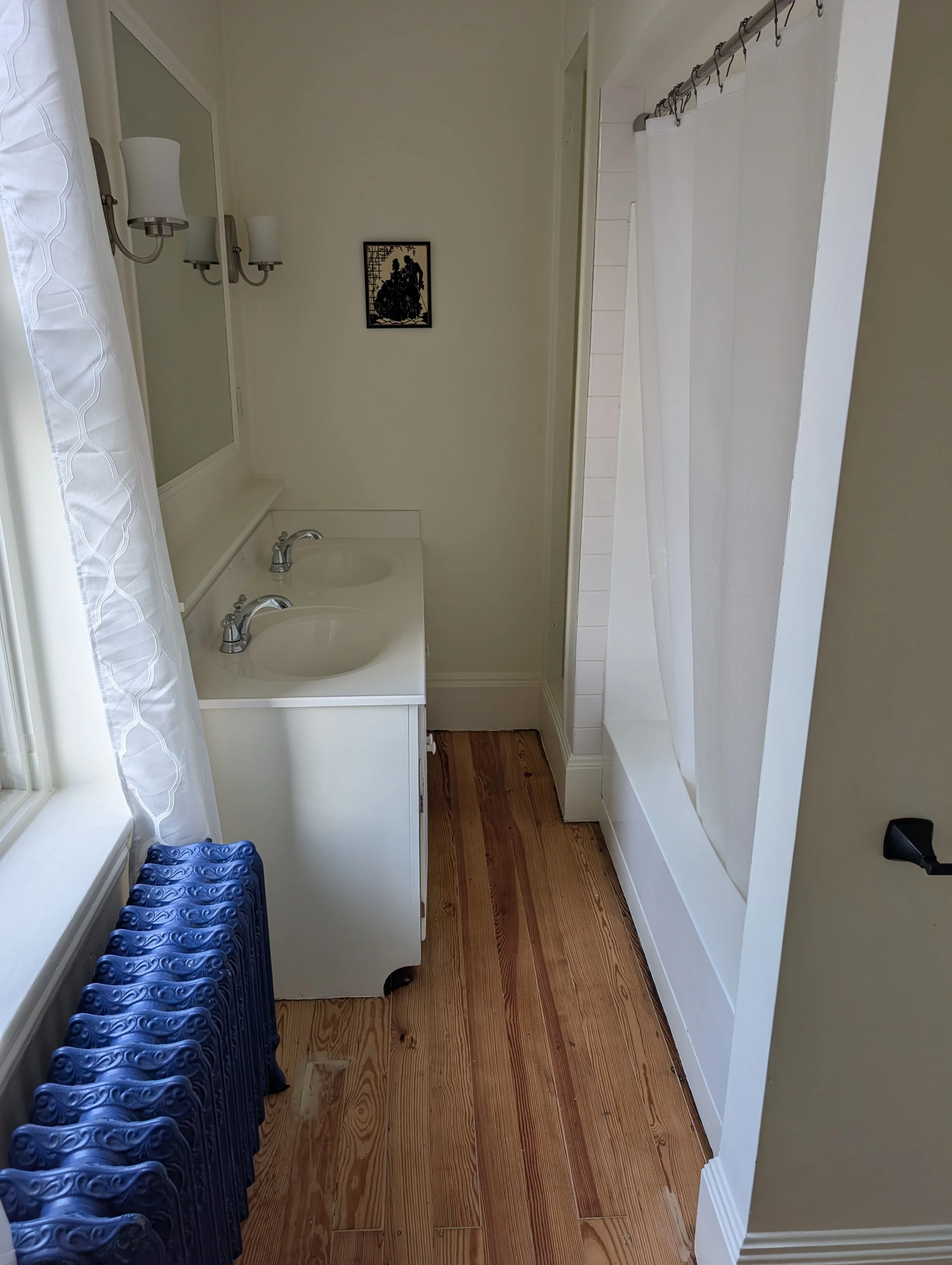 Private bathroom in the Northwest Room at Bella Vista Bed and Breakfast featuring a double-sink vanity, shower, natural light, and restored charm in Akron, Pennsylvania.