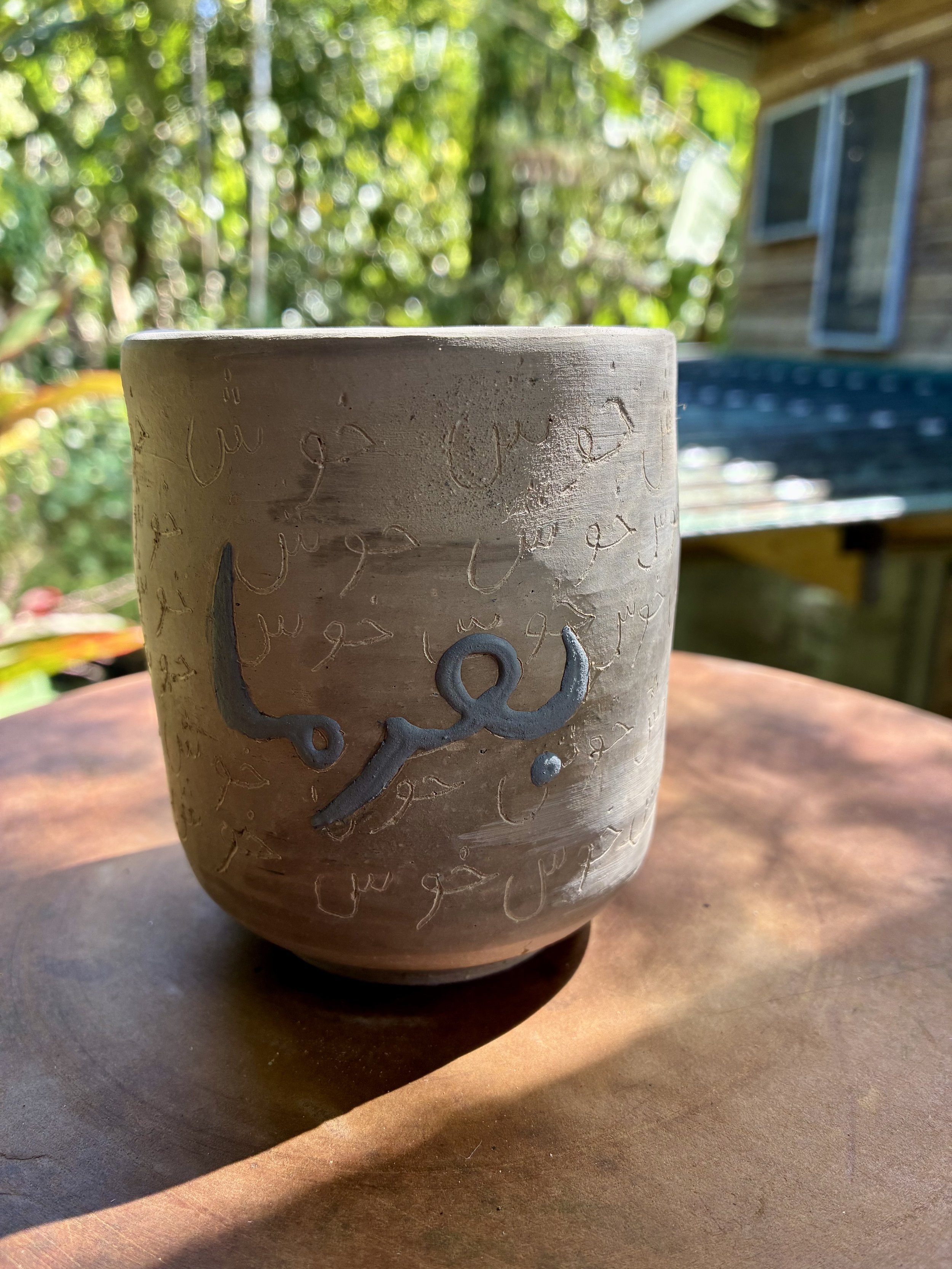 FARSI/CHINESE TEA CUP: Wen Xiang Bei (aroma cup) recycled clay, slip trailed farsi script 'Berfarma' (welcome) and engraved Farsi script 'khosh' (joy) (work in progress)