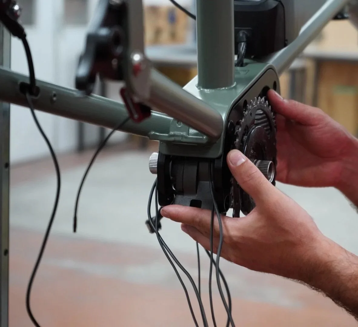 Une personne ajustant ou assembleant la transmission d'un vélo ou d'une machine mécanique.