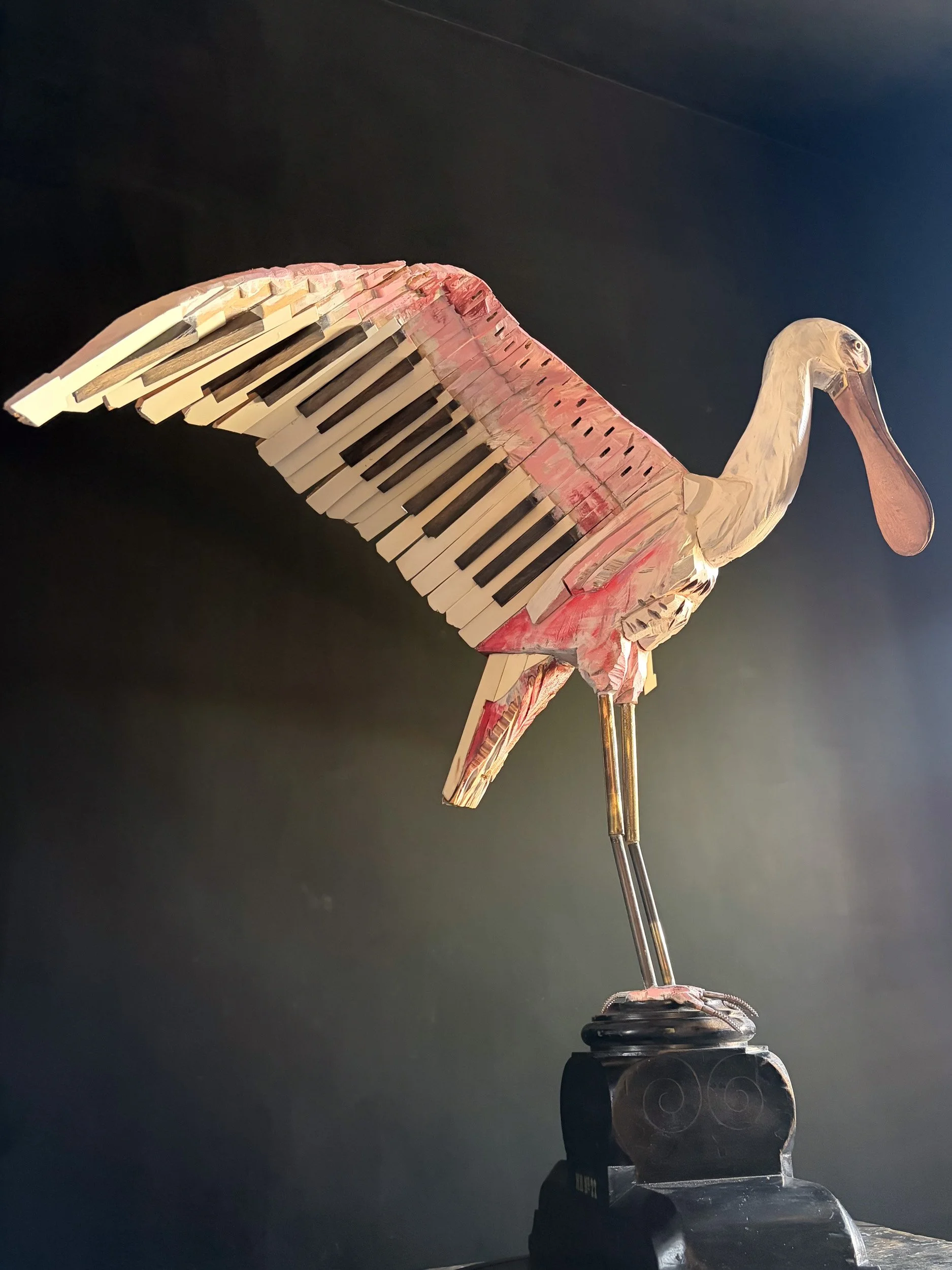 Roseate Spoonbill sculpture made from piano parts shown from side view.