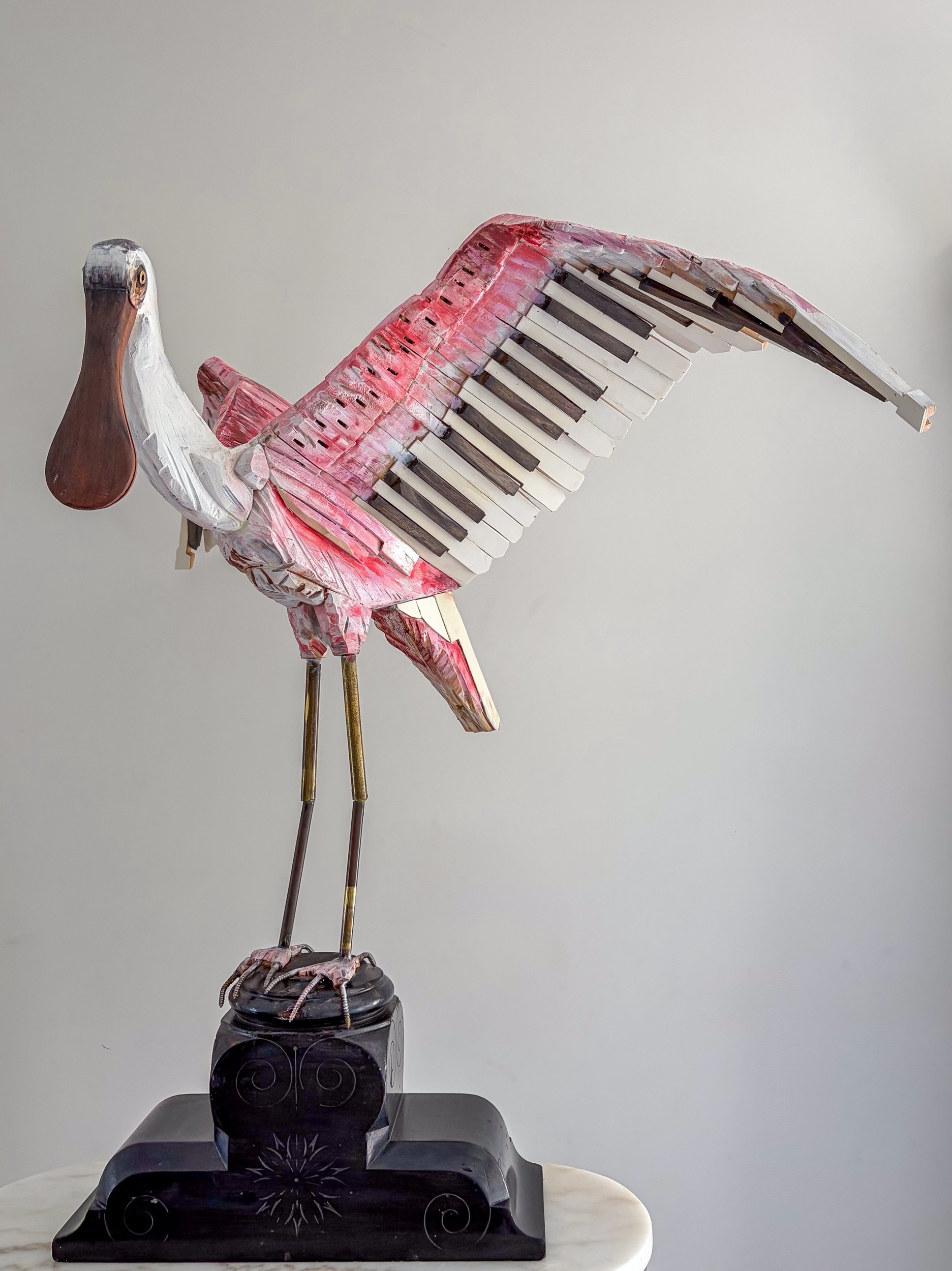 Roseate Spoonbill sculpture made from piano parts shown with side view.