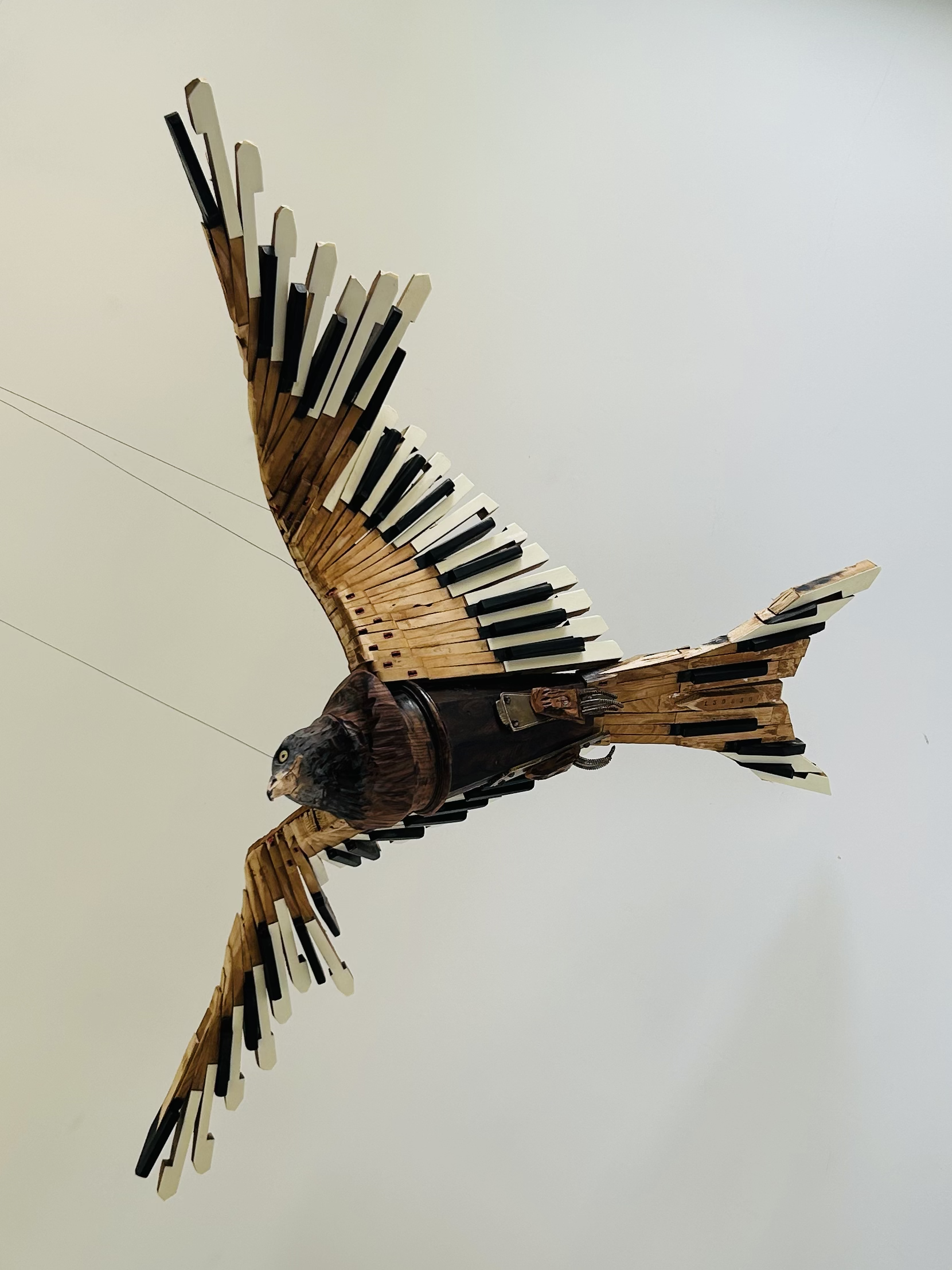 Red Kite sculpture made from recycled piano parts suspended from the ceiling.
