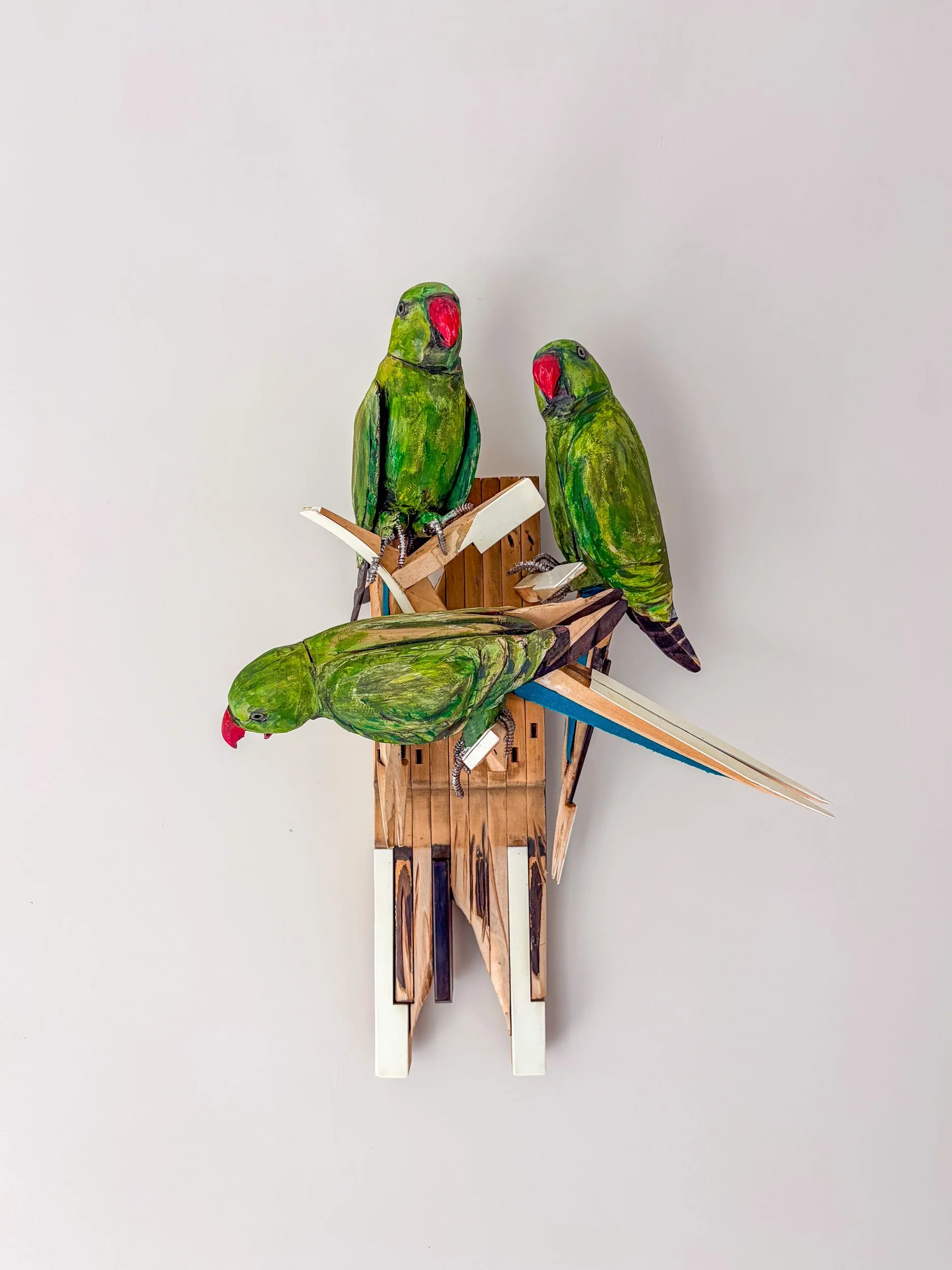 Sculpture of Three Parakeets in F Minor made of piano parts on wall.