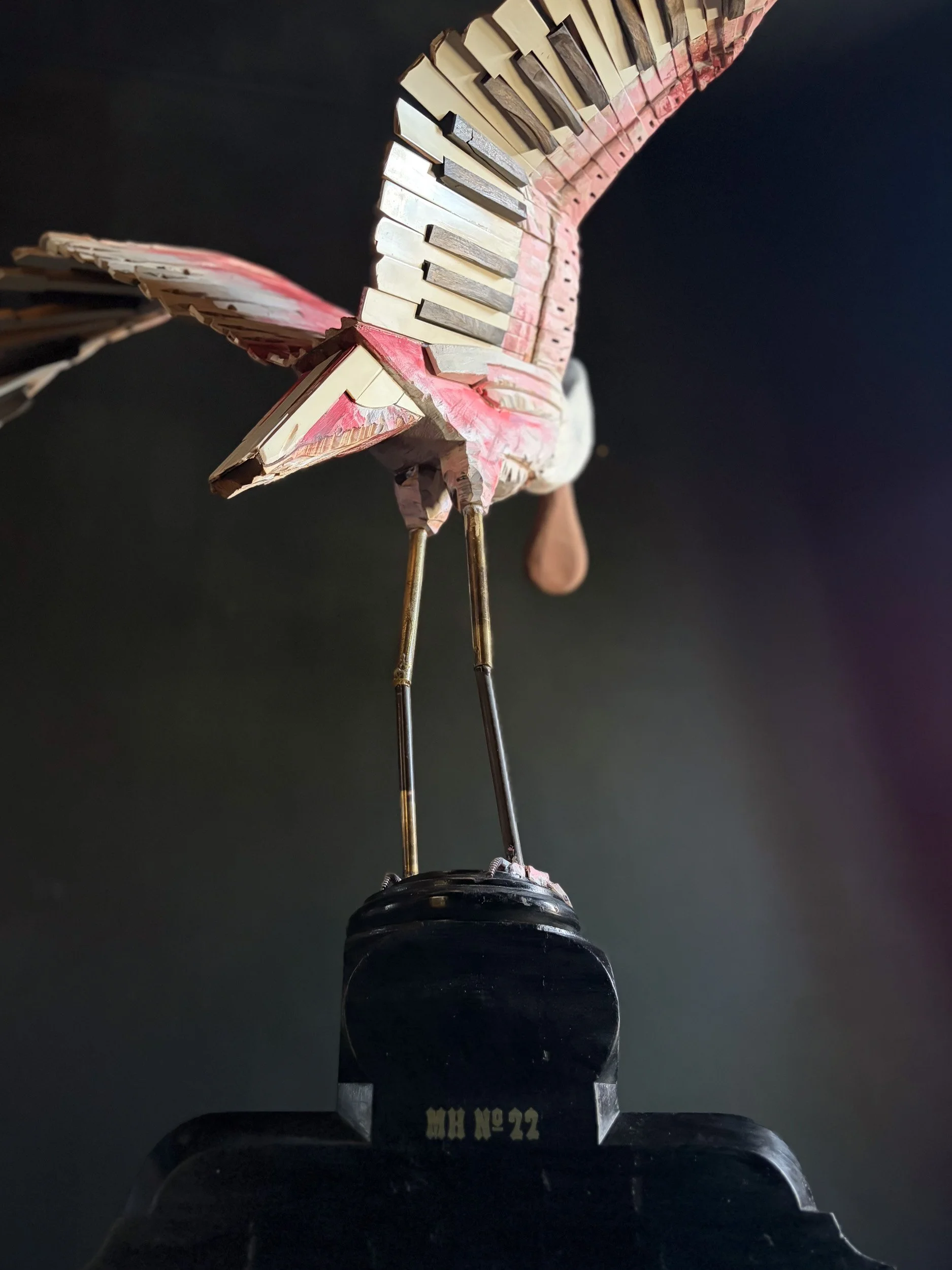 Roseate Spoonbill sculpture made from piano parts shown from behind with wings.