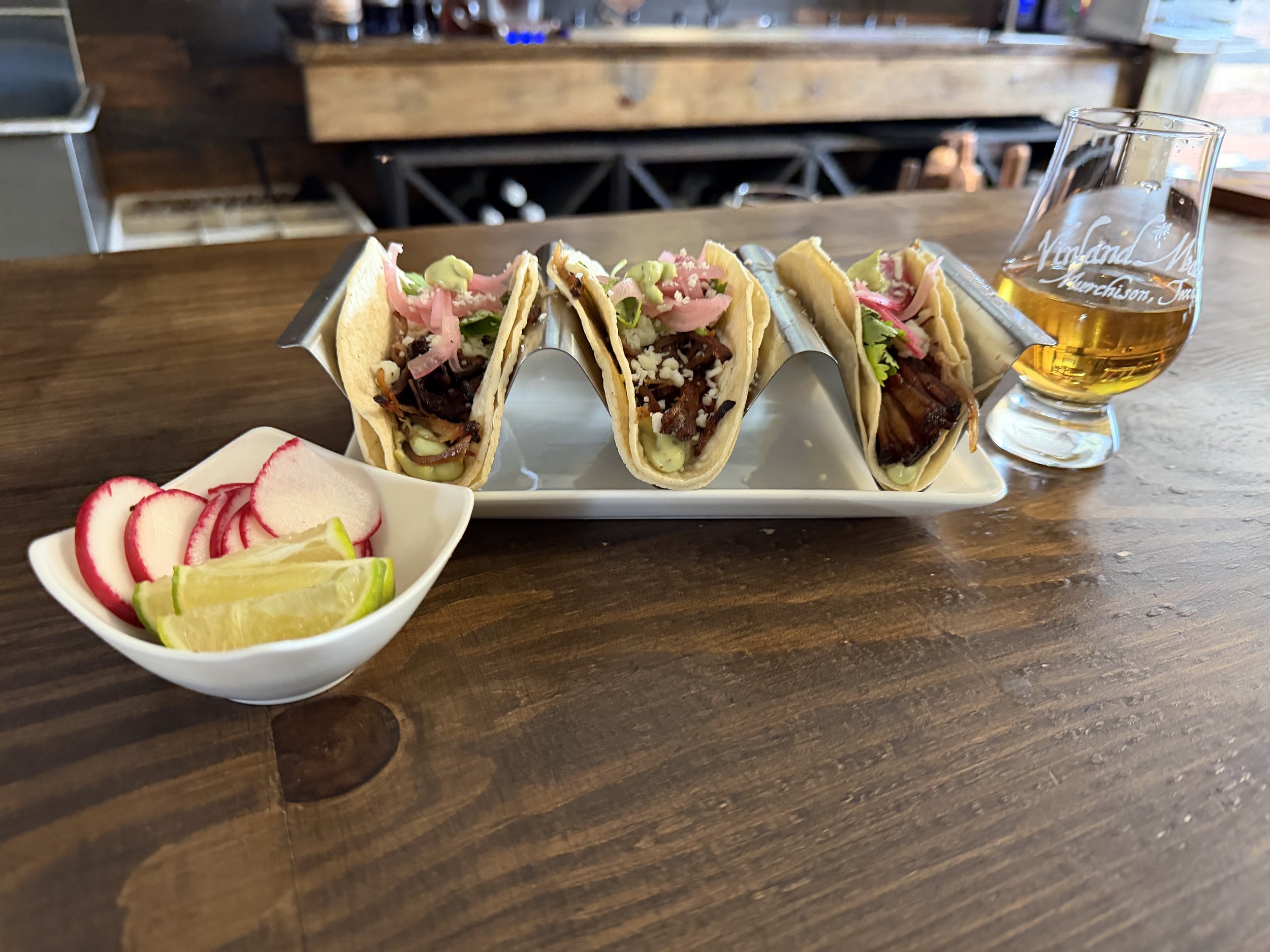 Vinland smoked pulled pork tacos with pickled onions, crema and lime