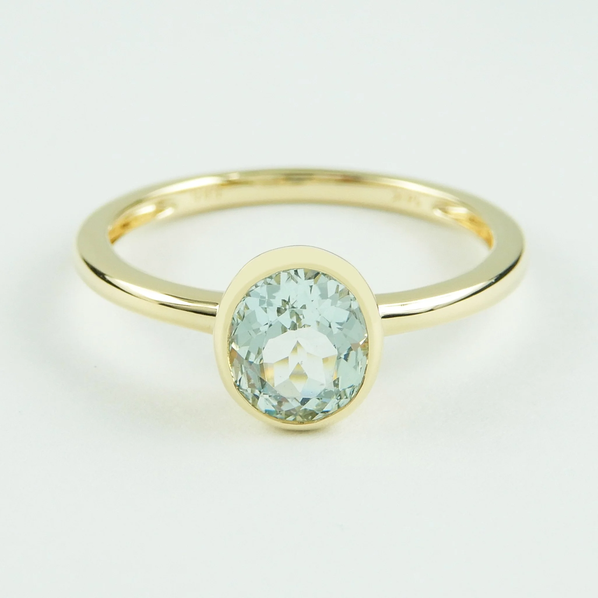 A refined 14k yellow gold ring featuring a natural aquamarine in a sleek bezel setting, designed for everyday elegance and longevity.