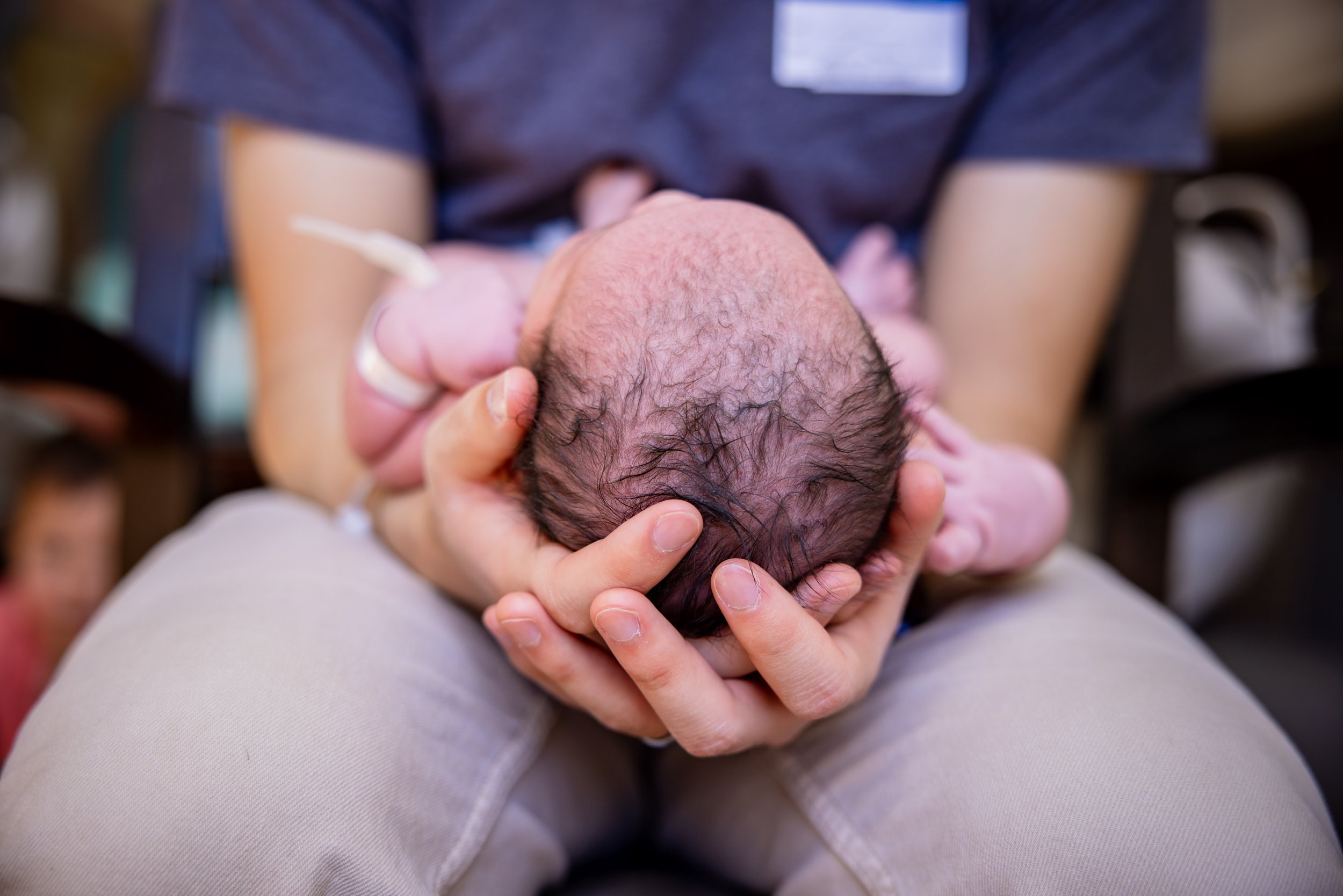 Newborn baby in dads hands at a fresh 48 photography session at Doctor's Hospital of Augusta, GA.