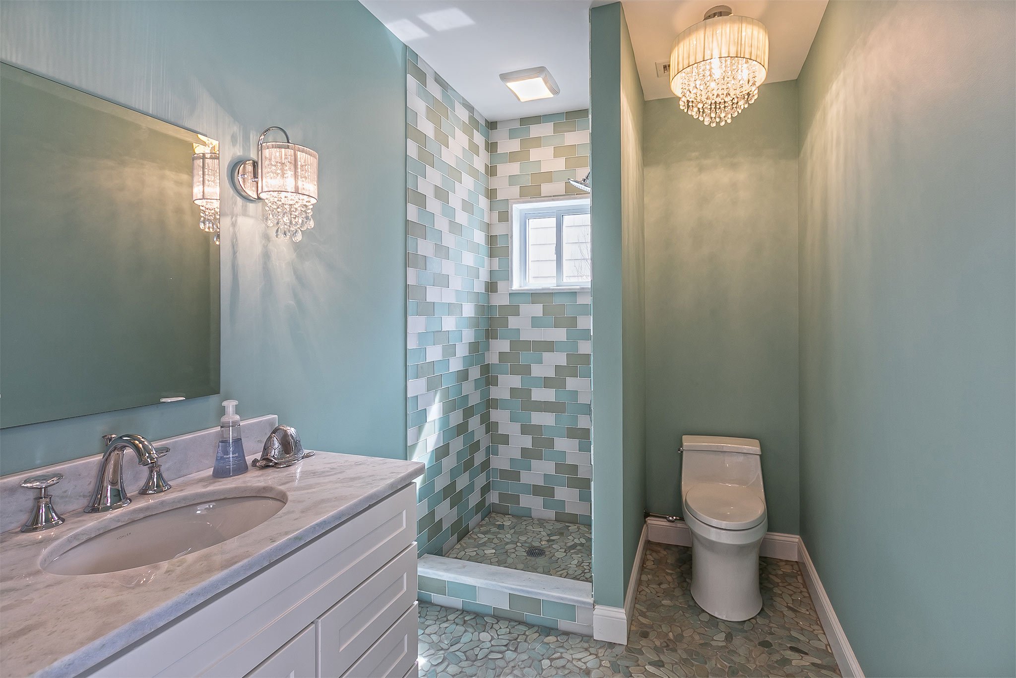 Bathroom
The bathroom extends the cottage’s dialogue between indoors and out. Subtle stone surfaces meet soft daylight, while just beyond the door, an outdoor shower blurs the line between design and nature. Function gives way to feeling — the luxury