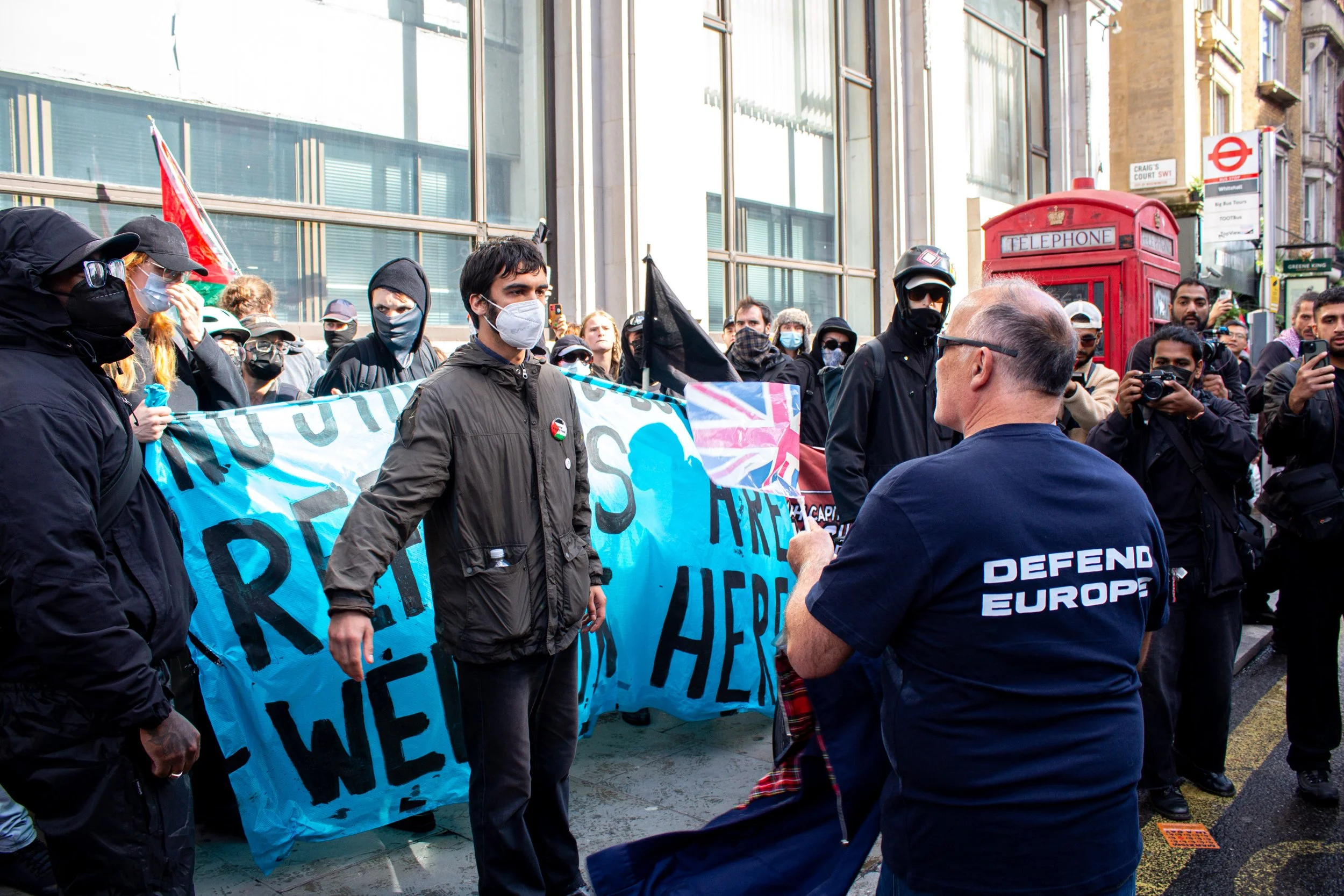 Members of a 'black block' in the counter protest are confronted by a member of the far-right.