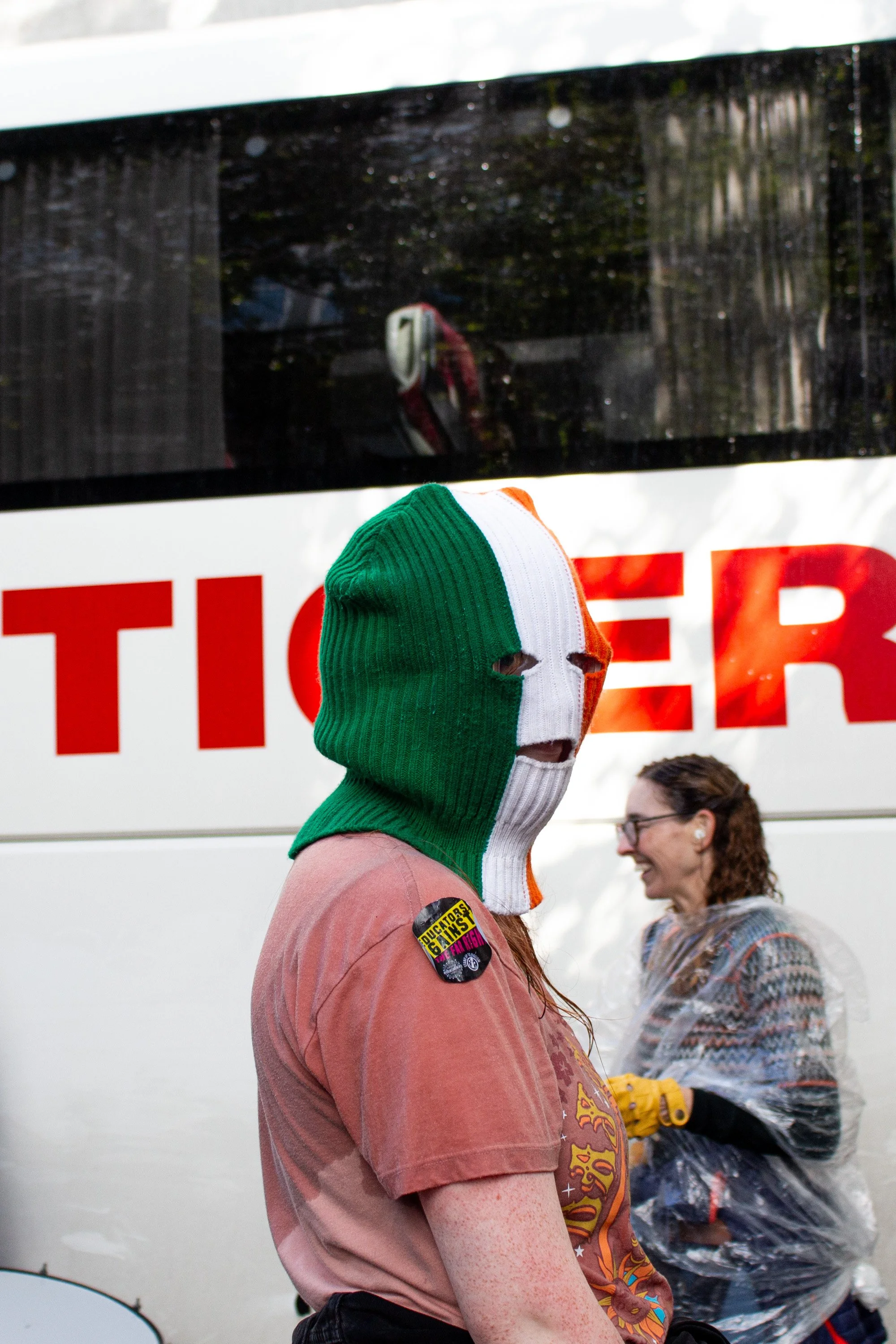 A protestor wears a balaclava in the colours of the Irish flag.