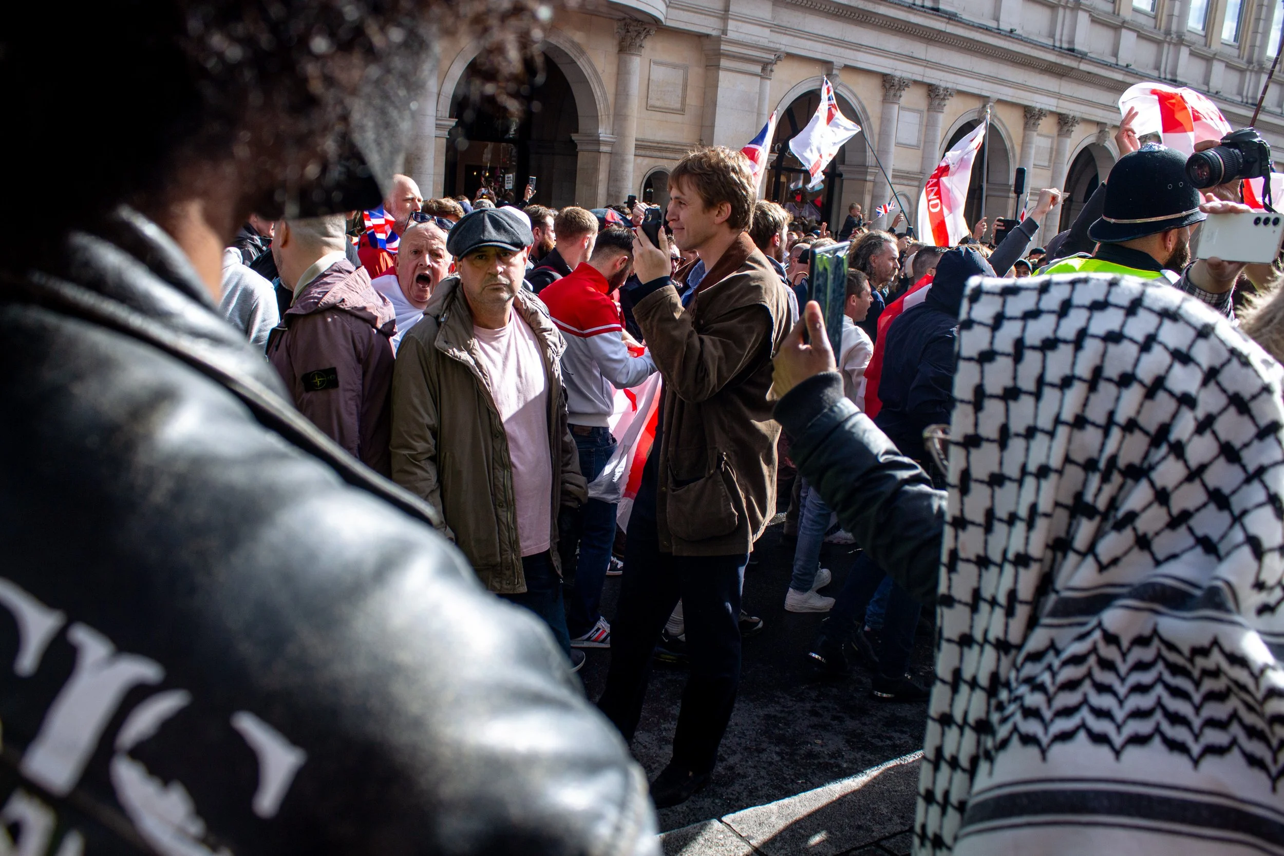 Men from the far-right shout abuse while the protests merge.