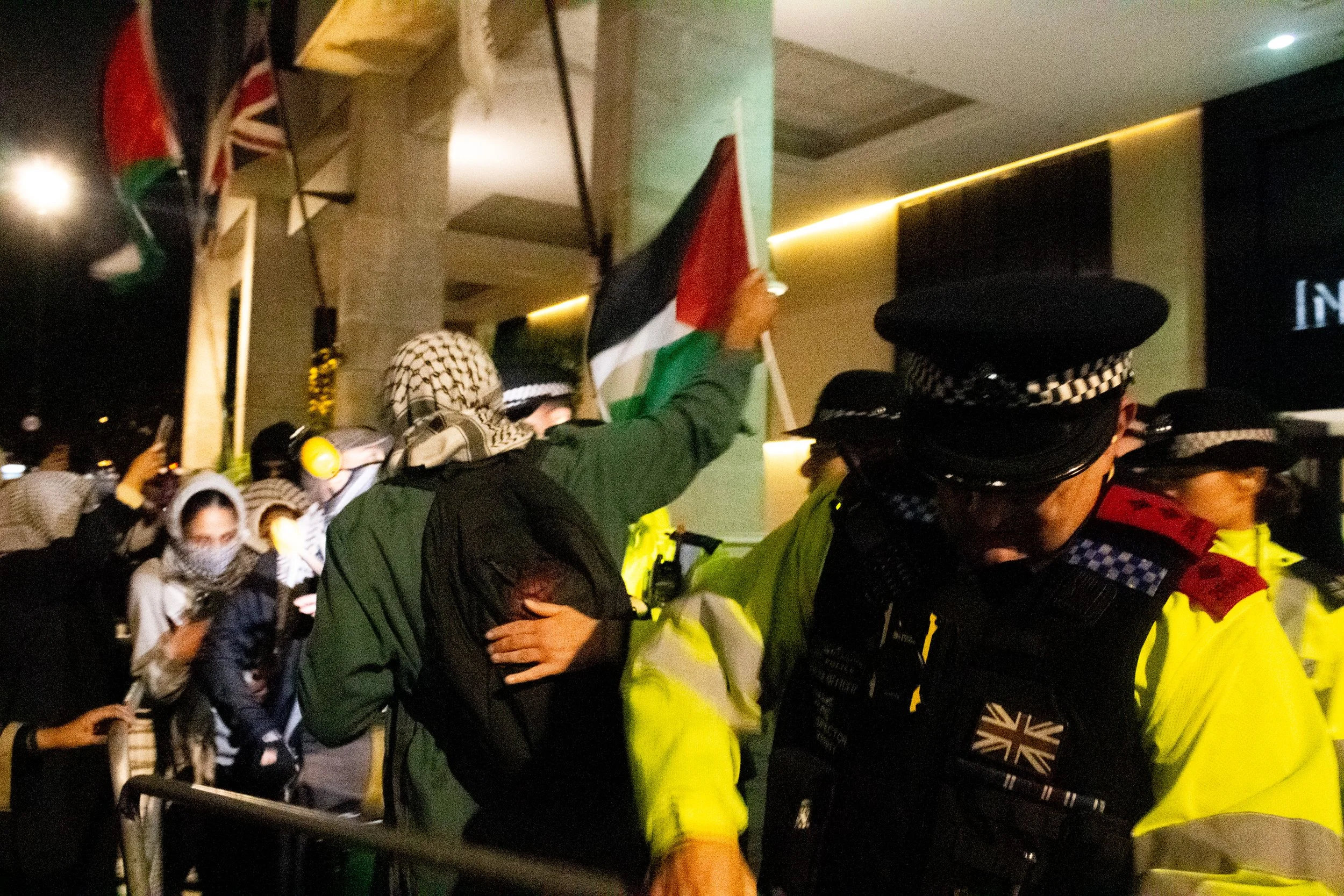 Police shove protestors out of the way as they re-secure metal gates, preventing protestors from coming closer to the hotel in which Herzog was staying, 2025.