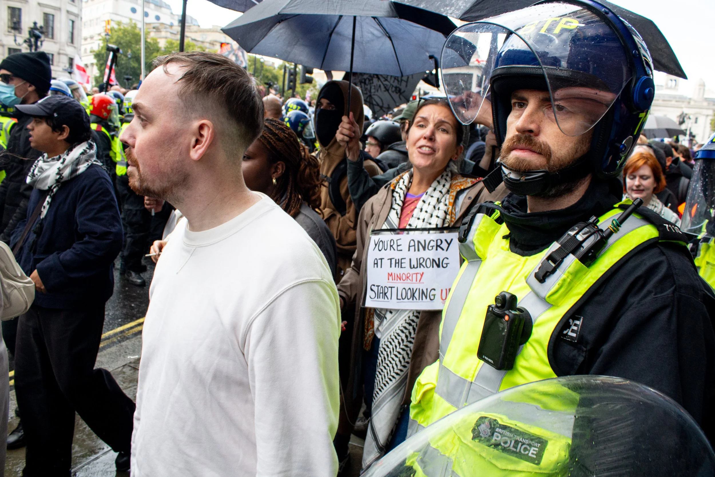 A group of counter protestors are brought through the far-right crowd and onto the other side.