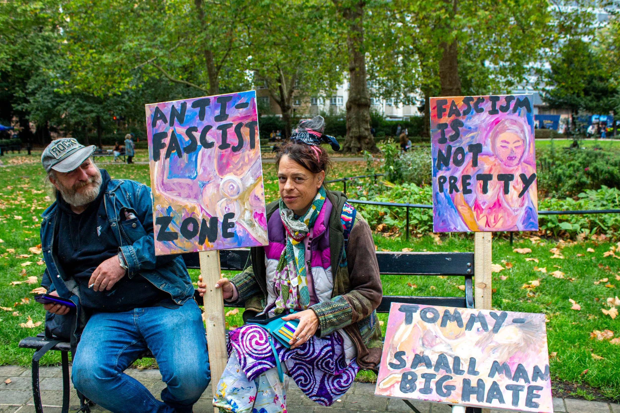 An artist sits in Russel Square with her paintings, which she recently converted into protest signs.