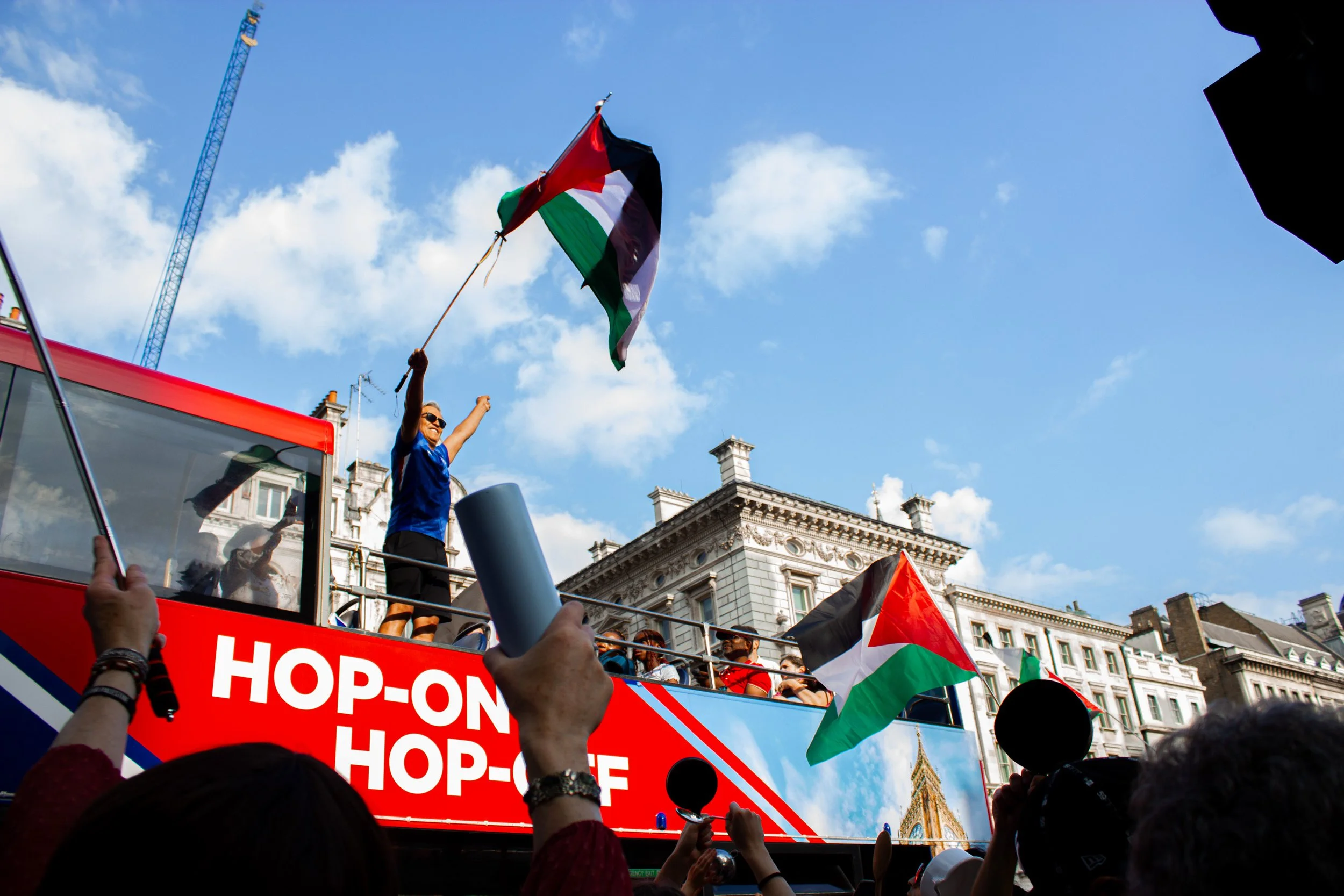 A tourist participates in a protest outside Downing Street, during which protestors condemned the British governmnet's ongoing complicity in the famine and genocide in Gaza, 2025.