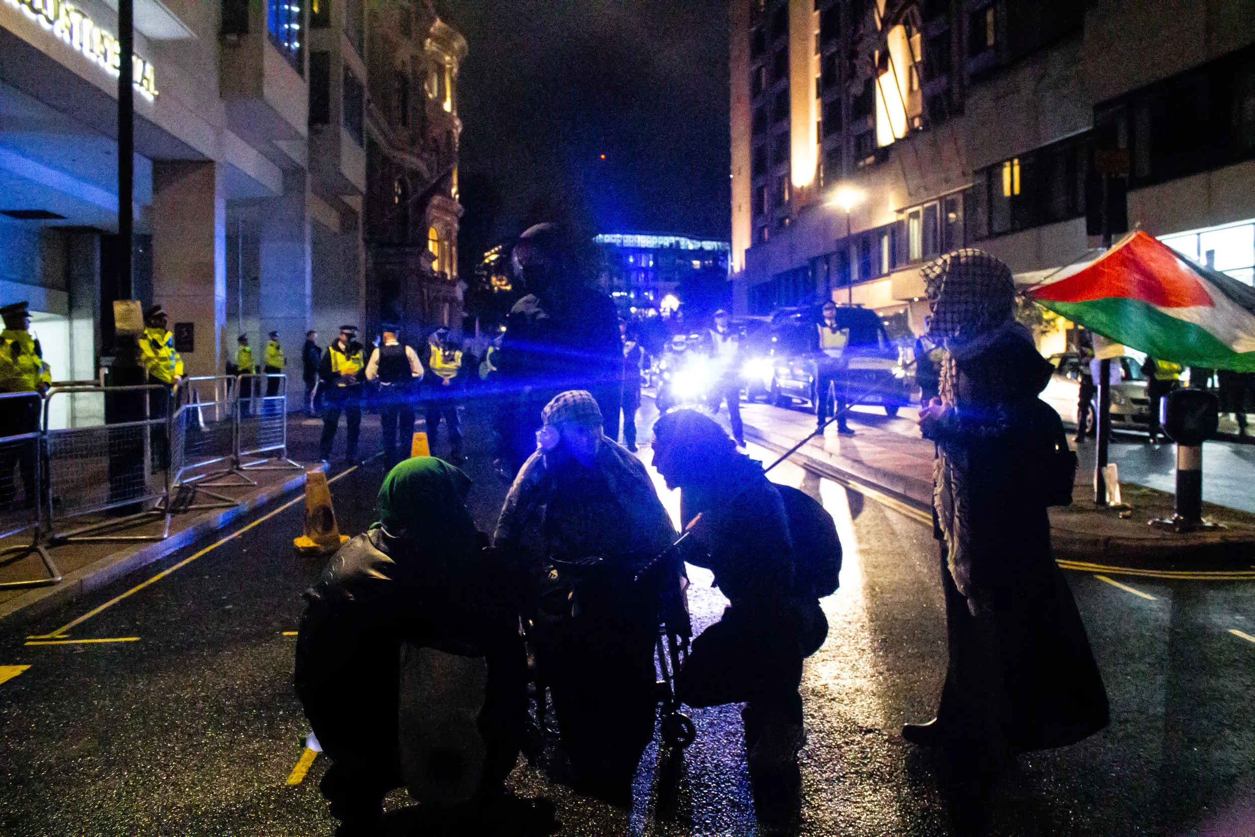 Police suround and grossly outnumber protestors calling for Herzog's arrest outside his hotel in London, 2025.