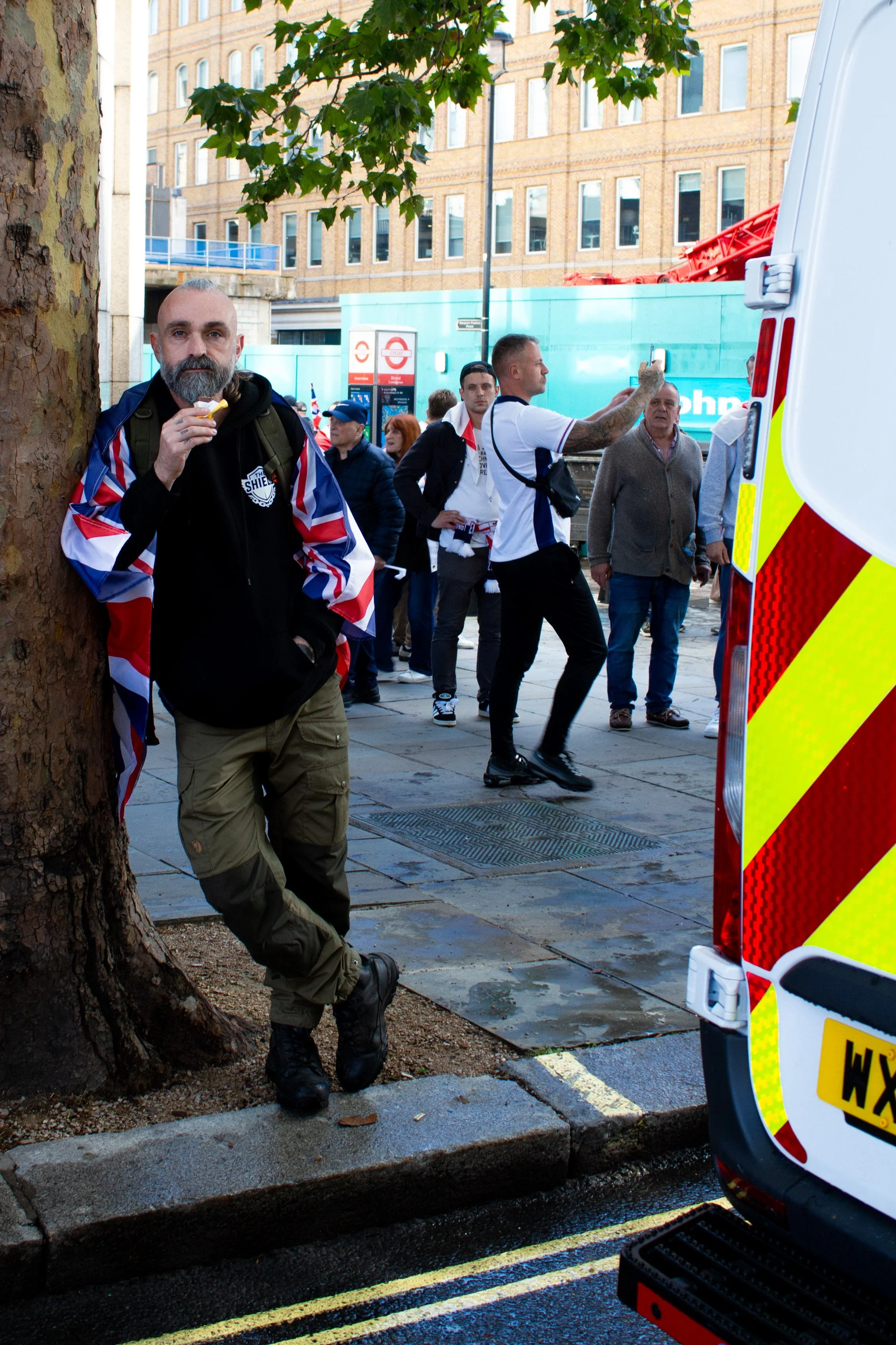 A far-right protestor on the side of the road near Charing Cross Station.