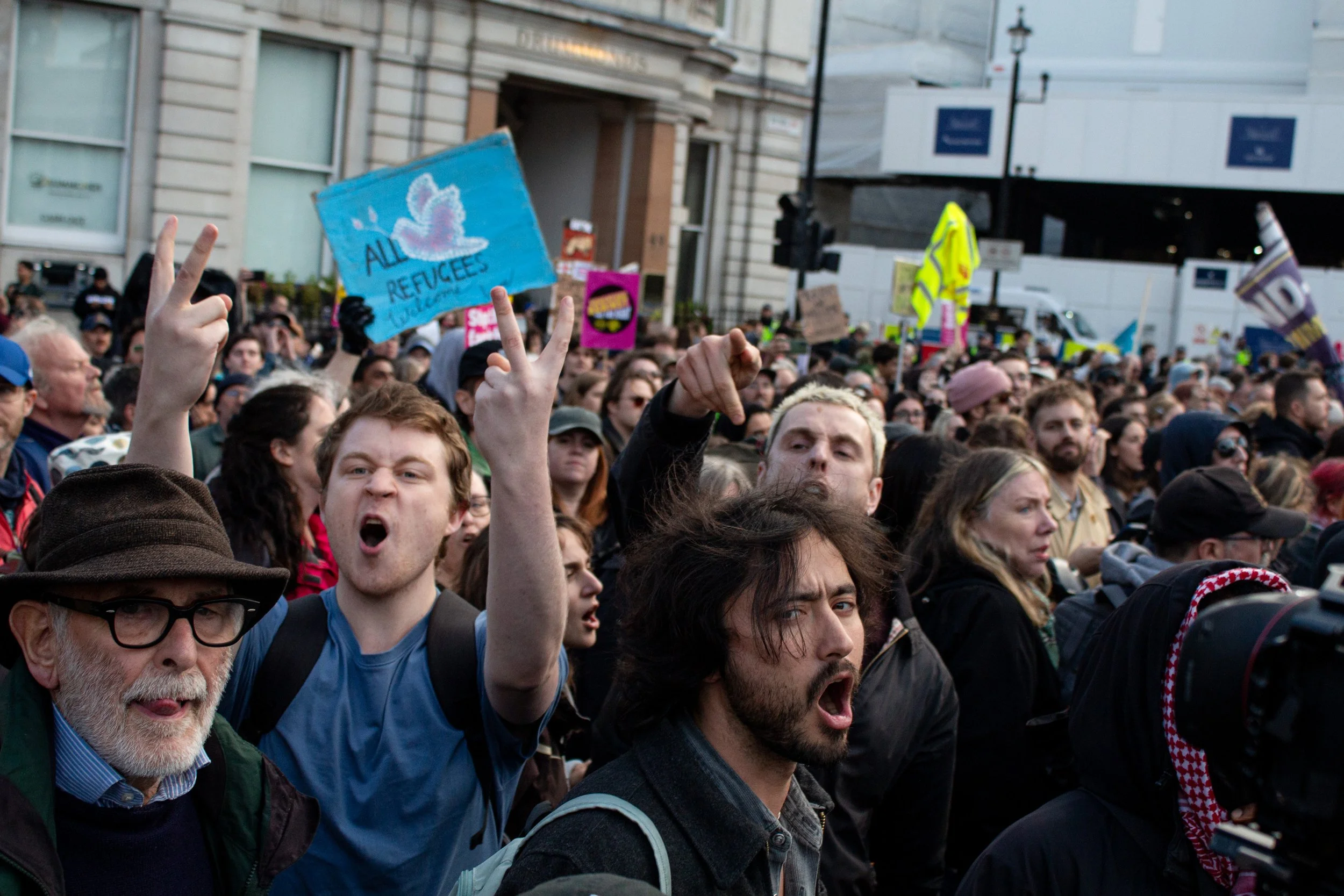 Counter protestors gesture explicitly at the far-right as they are ushered out of Trafalgar Square by police.