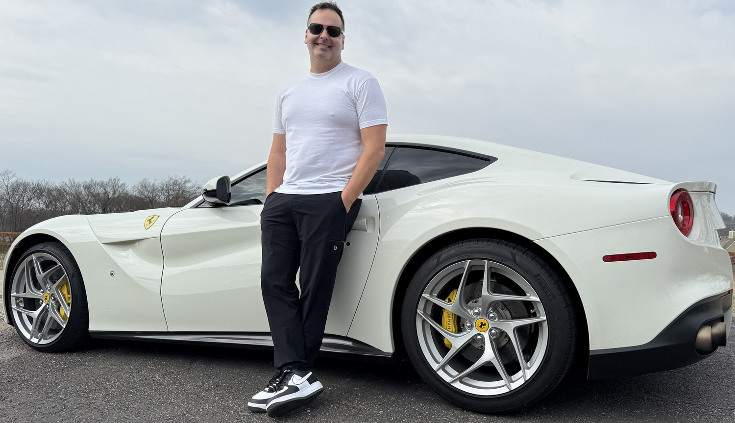 Jam standing beside his white Ferrari F12berlinetta