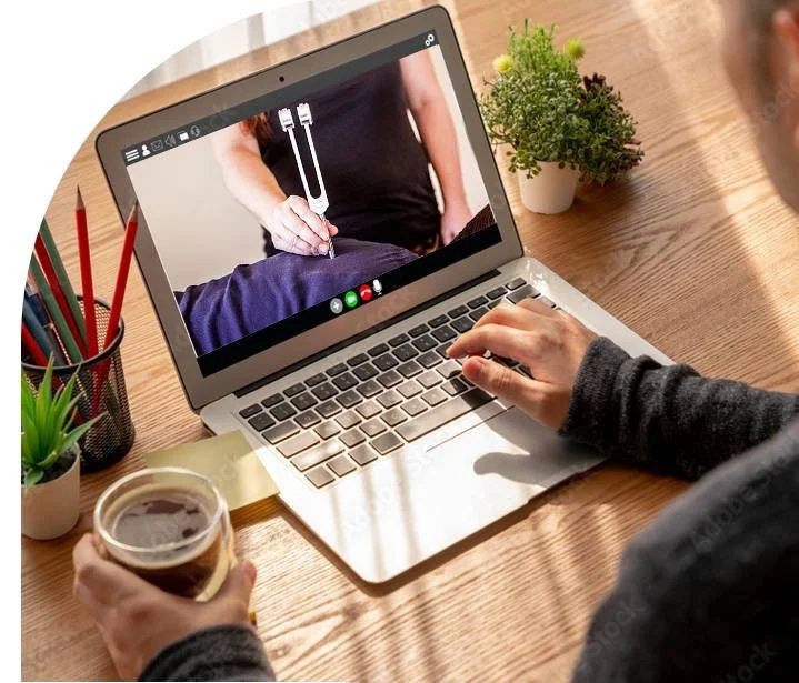 Person participating in a virtual consultation or appointment on a laptop, with a doctor visible on the screen.