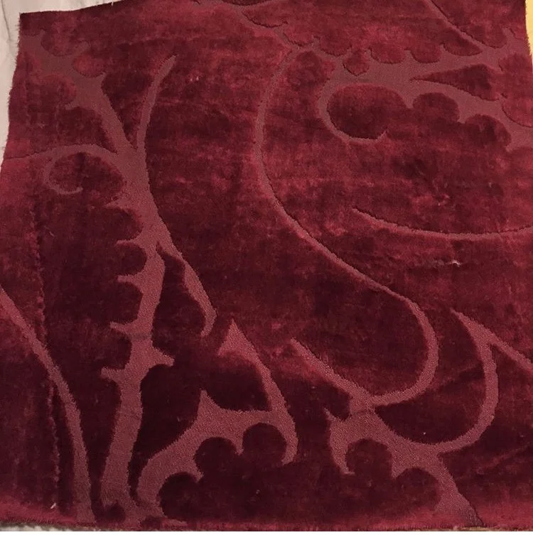 Close-up of a red fabric with a floral or ornamental pattern.